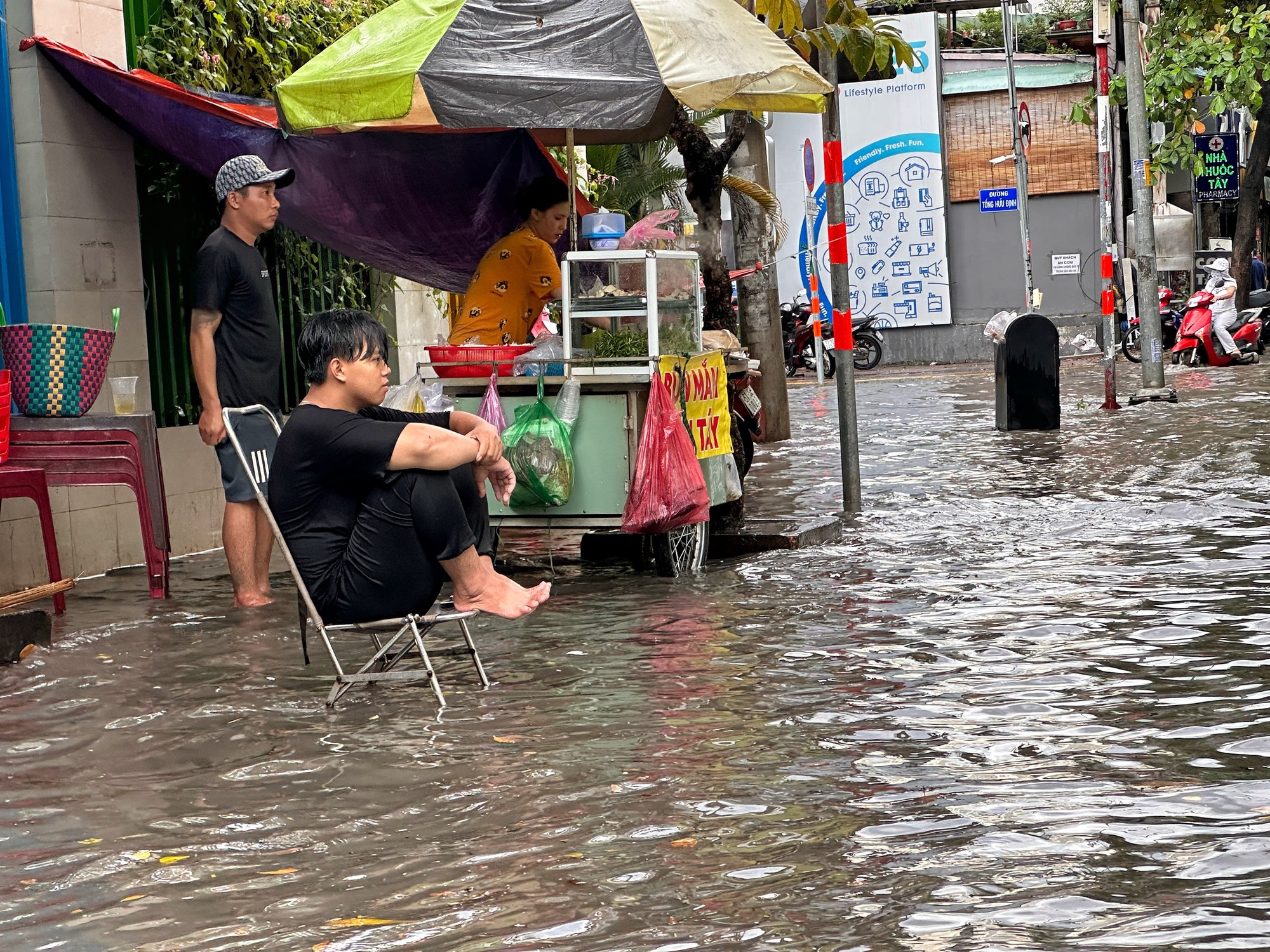 Mưa cực to, 'phố nhà giàu' TP.HCM mênh mông biển nước: Người xe bì bõm lội nước - Ảnh 1.