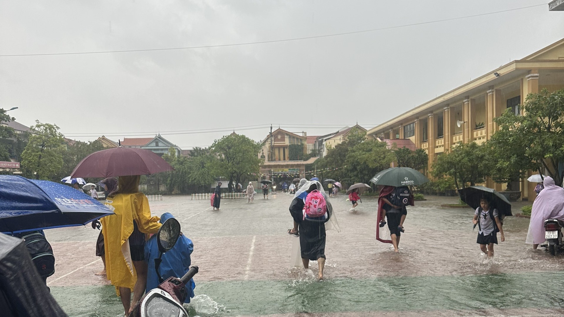 Quảng Bình: Lụt bất ngờ, phụ huynh nháo nhào đến trường, cõng con lội nước ra về - Ảnh 4.