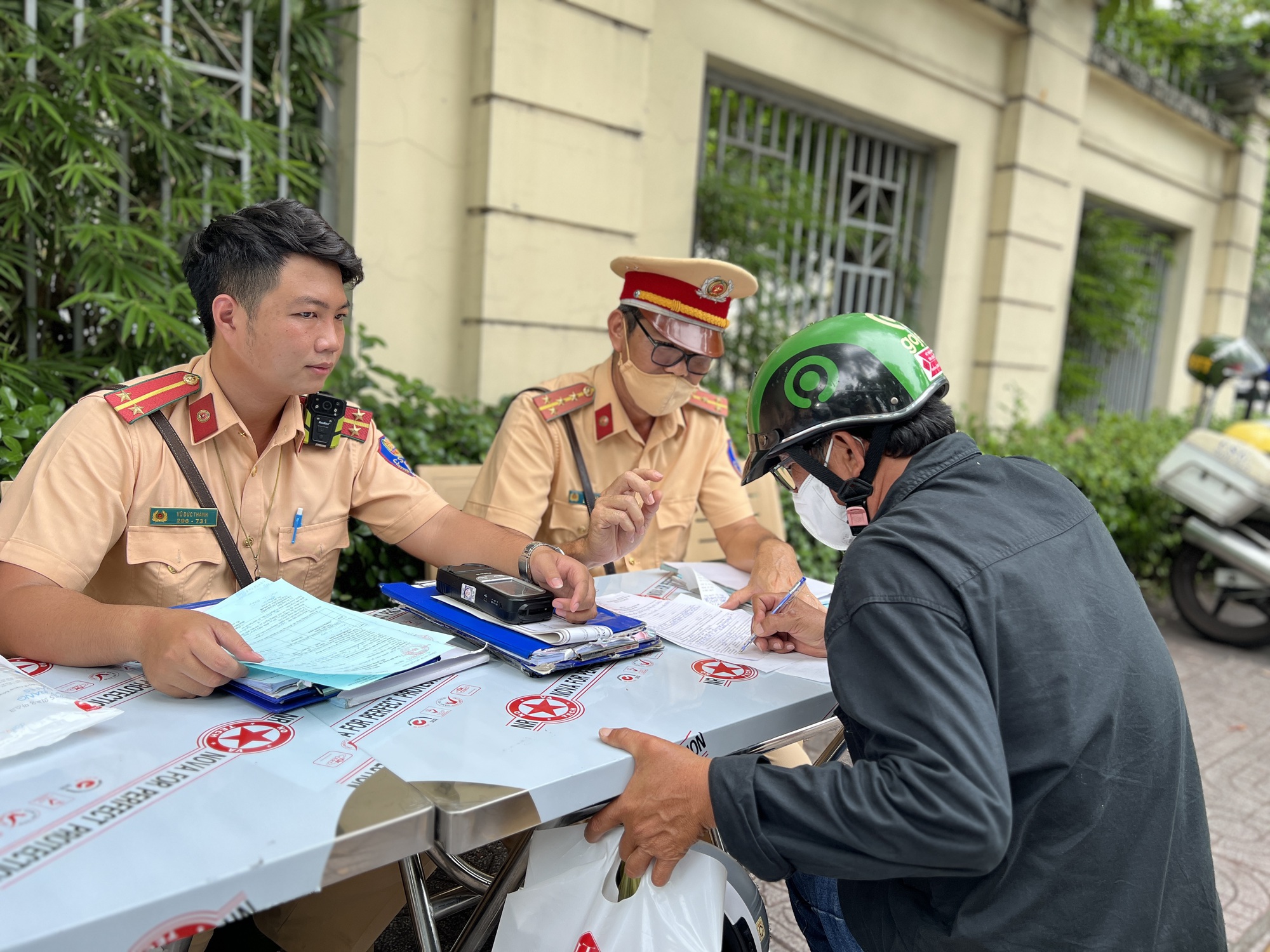 CSGT TP.HCM đo nồng độ cồn giữa trưa: Người than 'tốn thời gian', người đòi xem tem - Ảnh 2.