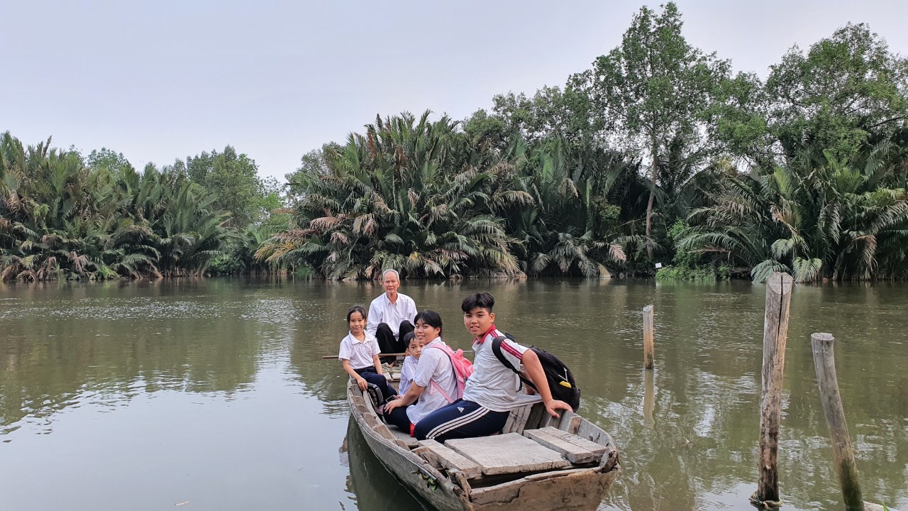 Cụ ông TP.HCM chèo ghe đưa đón 16 đứa cháu đi học mỗi ngày - Ảnh 1.