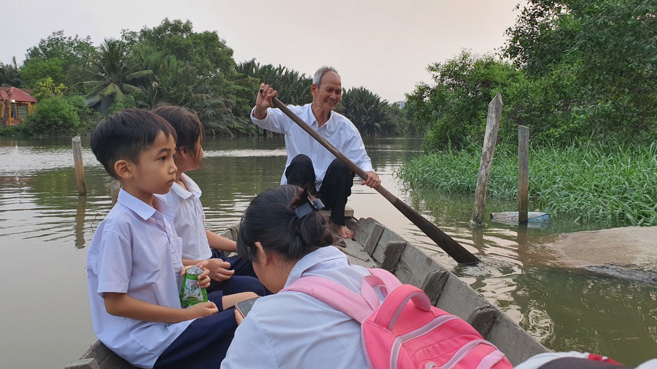 Cụ ông TP.HCM chèo ghe đưa đón 16 đứa cháu đi học mỗi ngày - Ảnh 2.