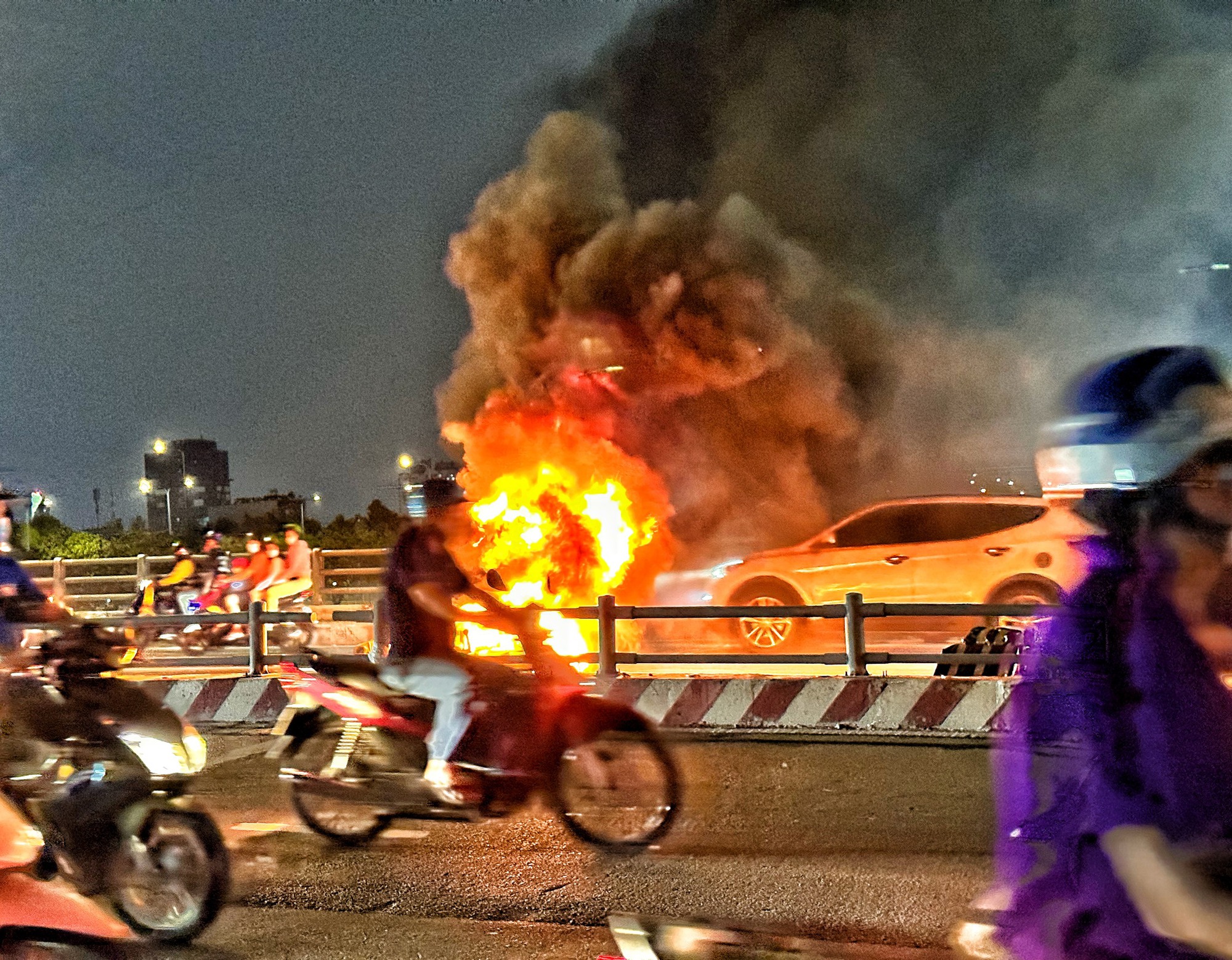 Xe máy bốc cháy phừng phừng trên cầu, người dân TP.HCM xúm lại dập lửa - Ảnh 1.