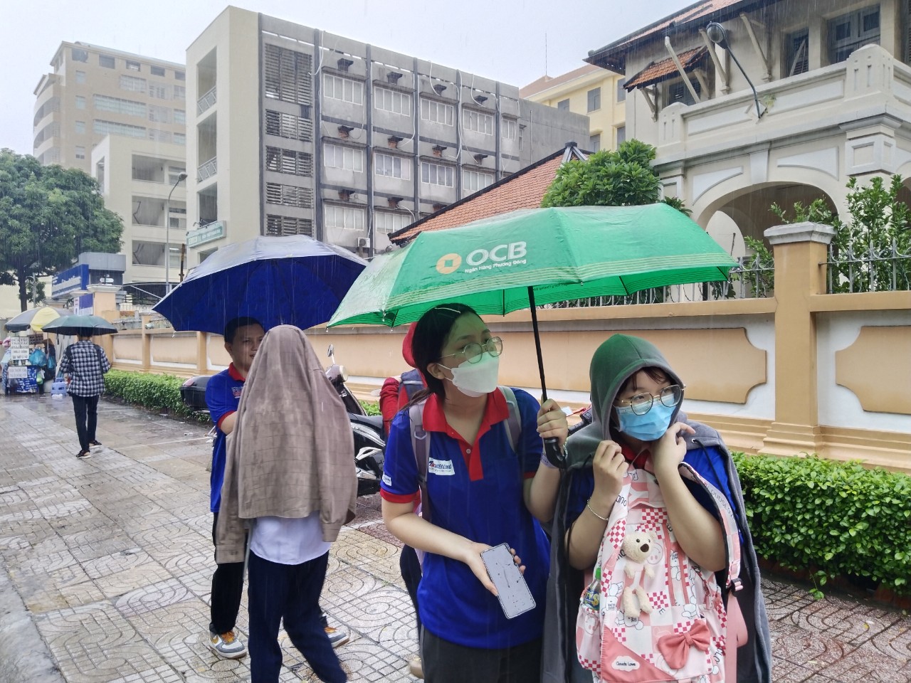 Phụ huynh lấy dù che mưa cho sinh viên tình nguyện viên - Ảnh 5.