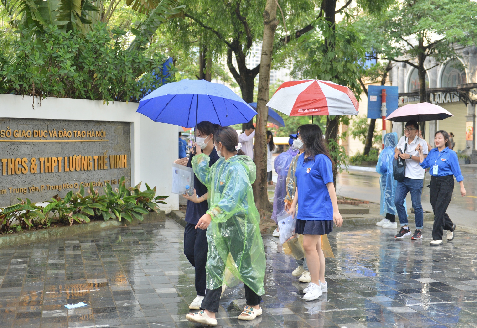 Thi tốt nghiệp THPT 2023: Thanh niên tình nguyện đội mưa che ô cho thí sinh - Ảnh 2.