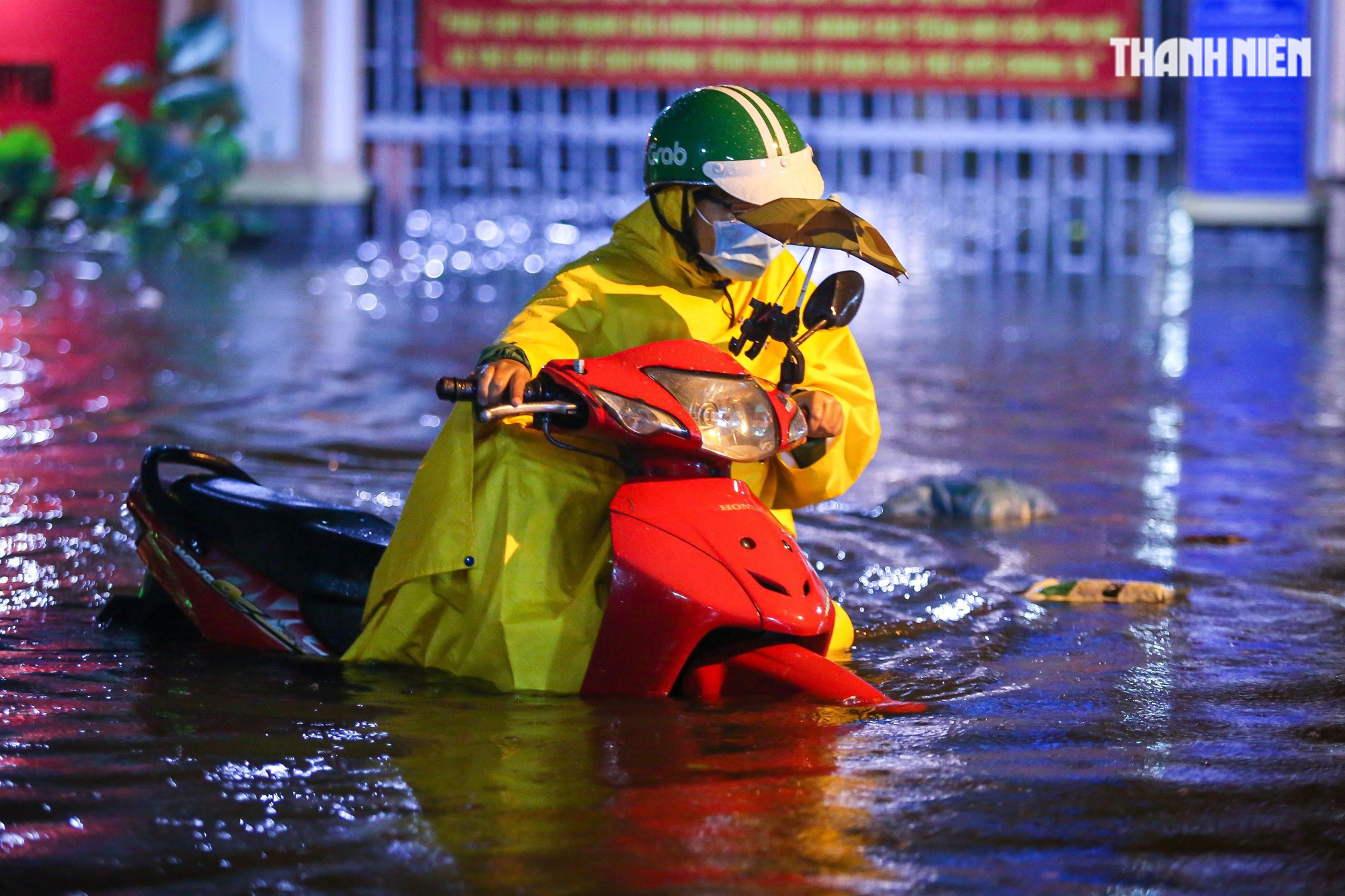 TP.HCM mưa lớn tối nay: Nước dâng tới yên, có người 'cõng xe' qua đoạn ngập - Ảnh 1.