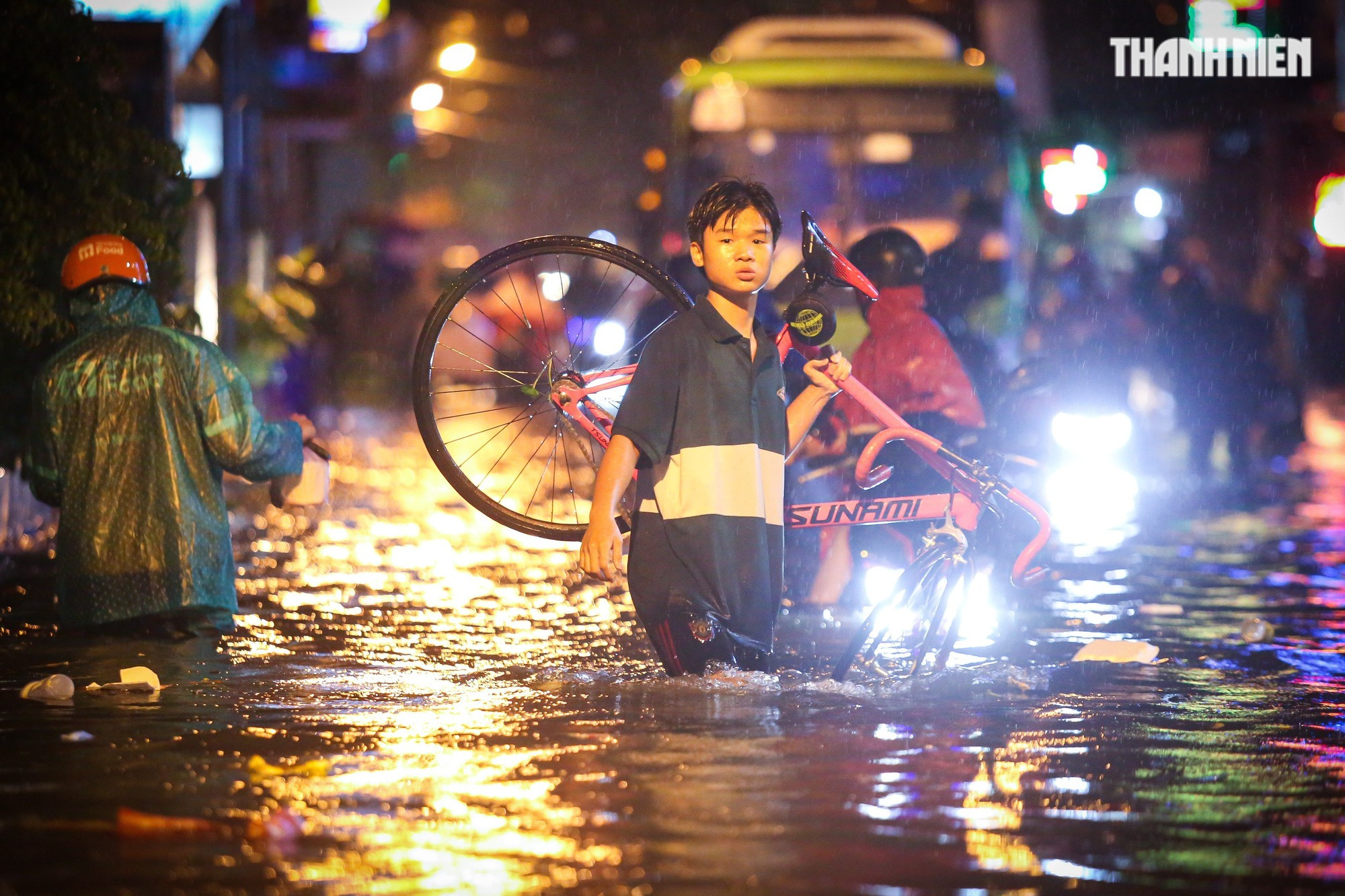 TP.HCM mưa lớn tối nay: Nước dâng tới yên, có người 'cõng xe' qua đoạn ngập - Ảnh 2.