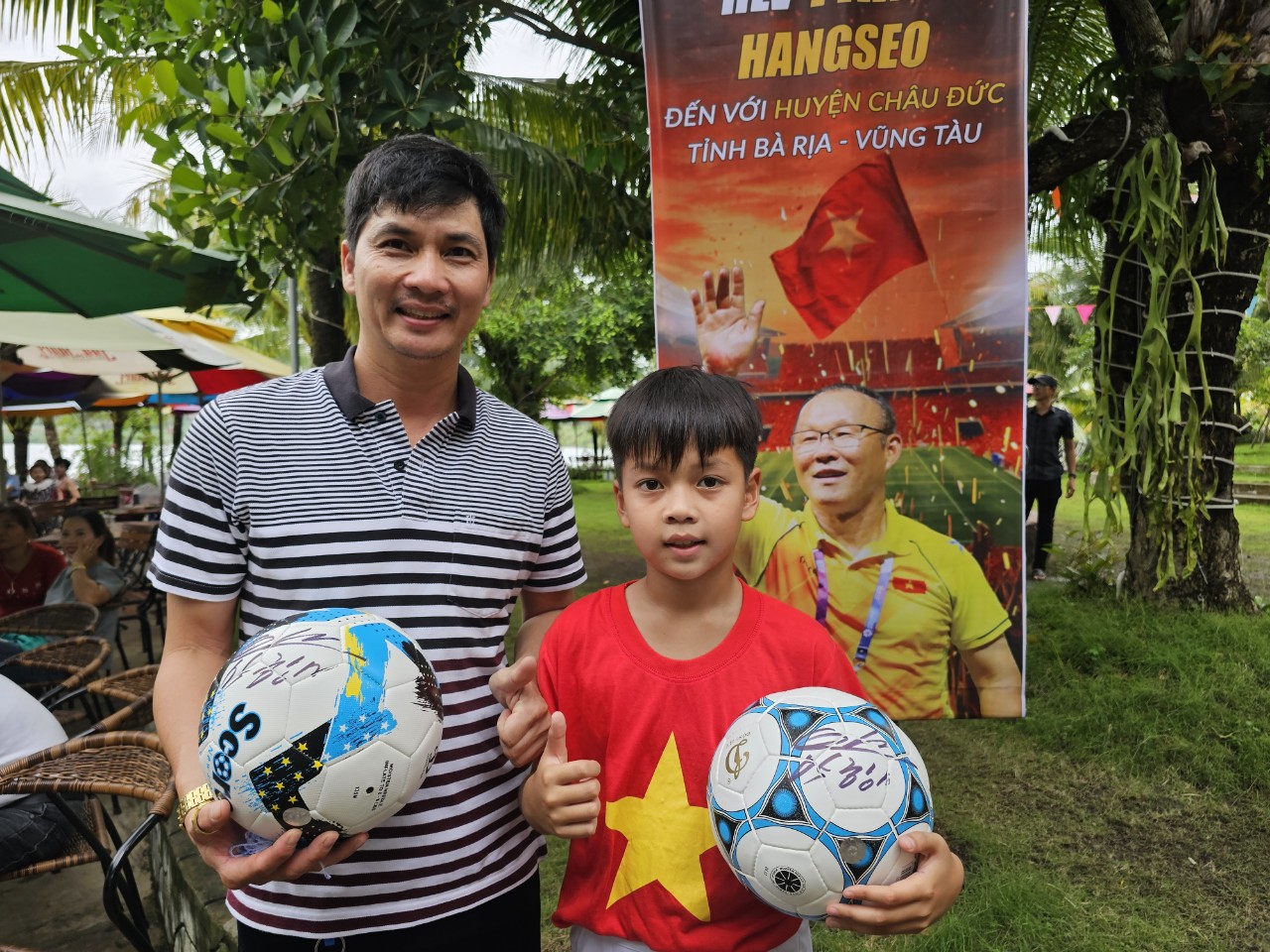 Anh Trân Minh Phú (sinh năm 1982) cùng con trai Trân Minh Khôi (2013) rạng rỡ bên trái bóng có chữ ký của ông Park