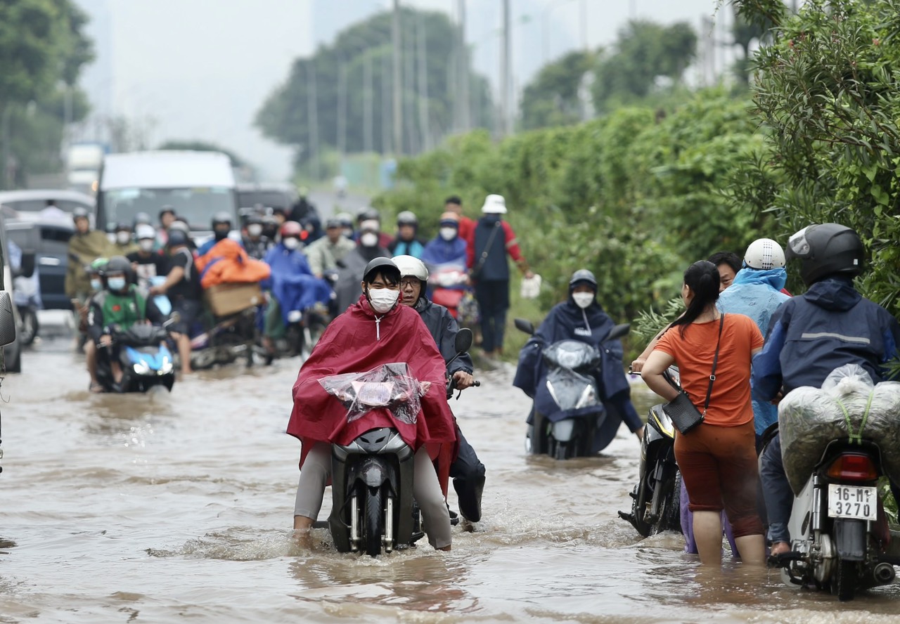 Đại lộ Thăng Long ngập sâu sau nhiều giờ mưa tạnh, người dân chật vật đi qua - Ảnh 2.
