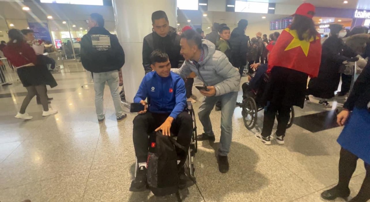 Phạm Xuân Mạnh bị đau nhức cổ chân, ngồi xe lăn khi xuống sân bay Nội Bài- Ảnh 2.