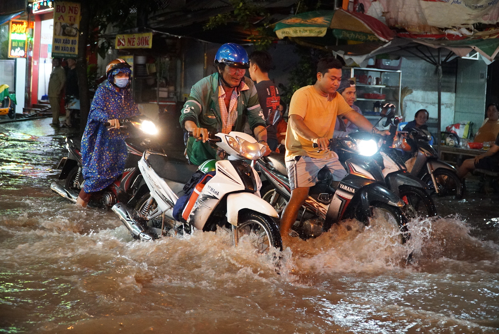 Nước từ cống lại tuôn ra cuồn cuộn, nhiều người được giúp dìu qua 'dòng thác' ở Thủ Đức- Ảnh 1.