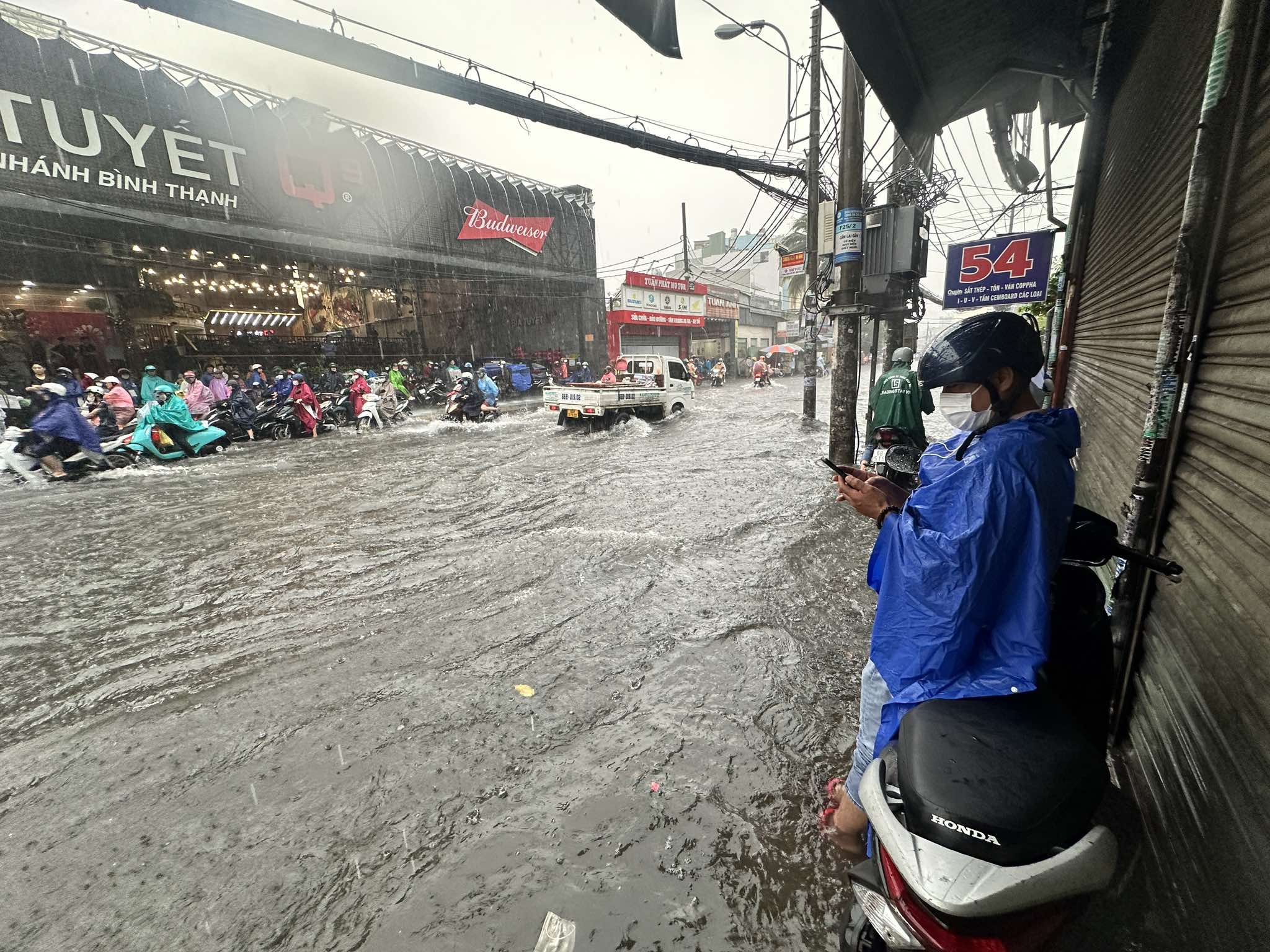 TP.HCM mưa lớn: Ngoài đường 'đứng hình giữa biển nước', trong nhà... khốn khổ chạy nước- Ảnh 1.