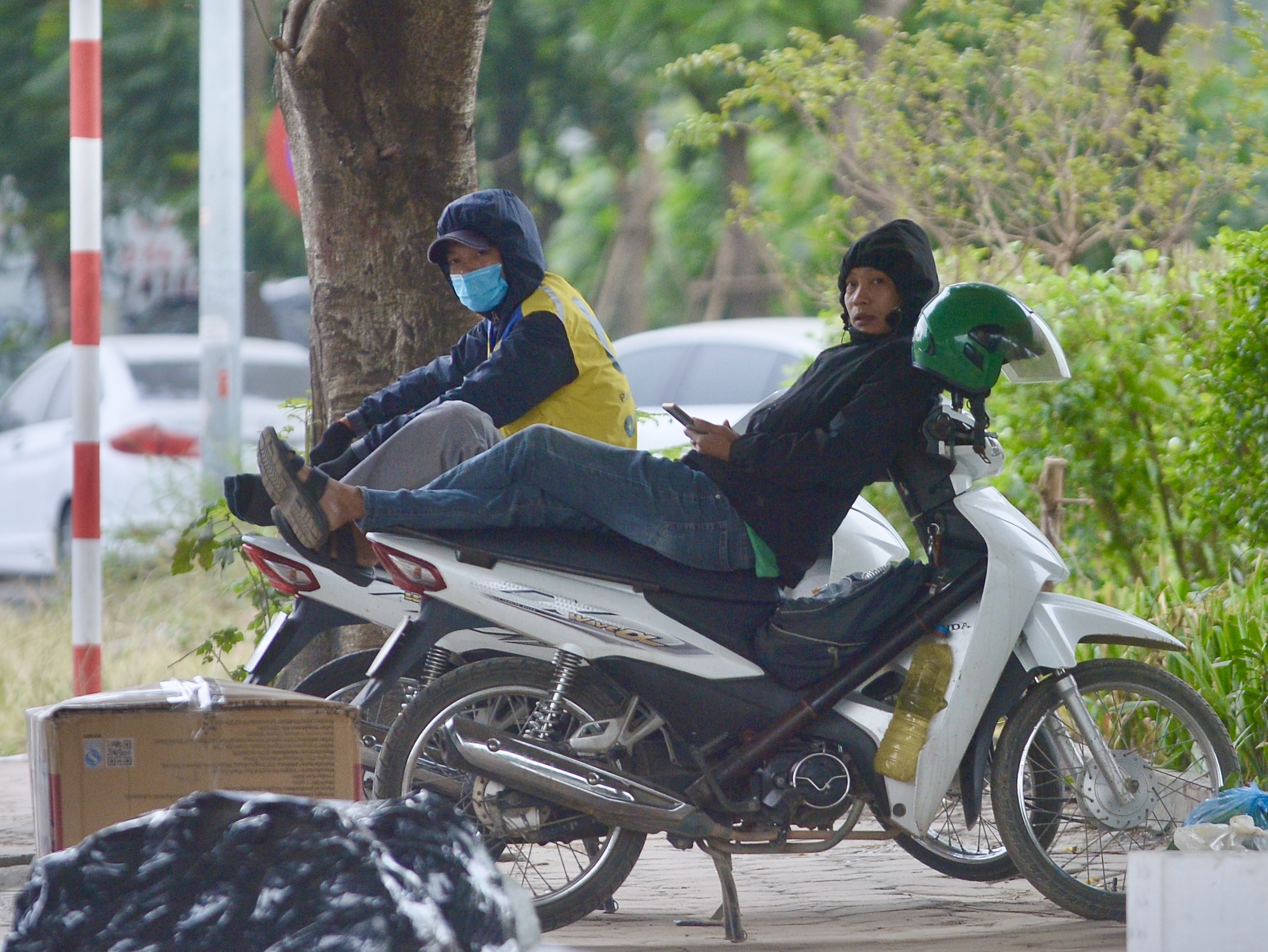 Hà Nội rét nhất từ đầu mùa đông, người dân mặc thêm áo mưa mưu sinh- Ảnh 7.