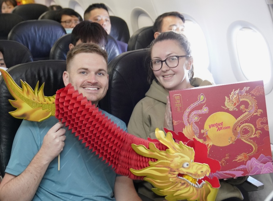 A person and person holding a red and yellow dragon  Description automatically generated