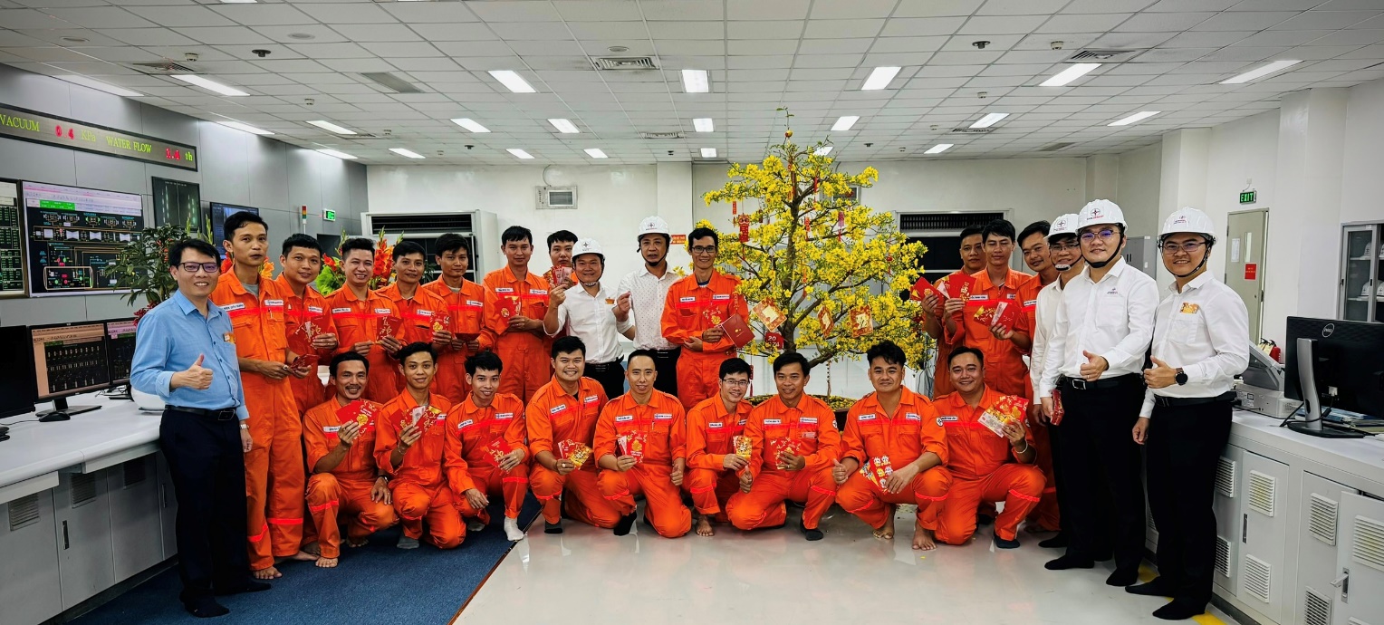 A group of people in orange jumpsuits posing for a photo  Description automatically generated