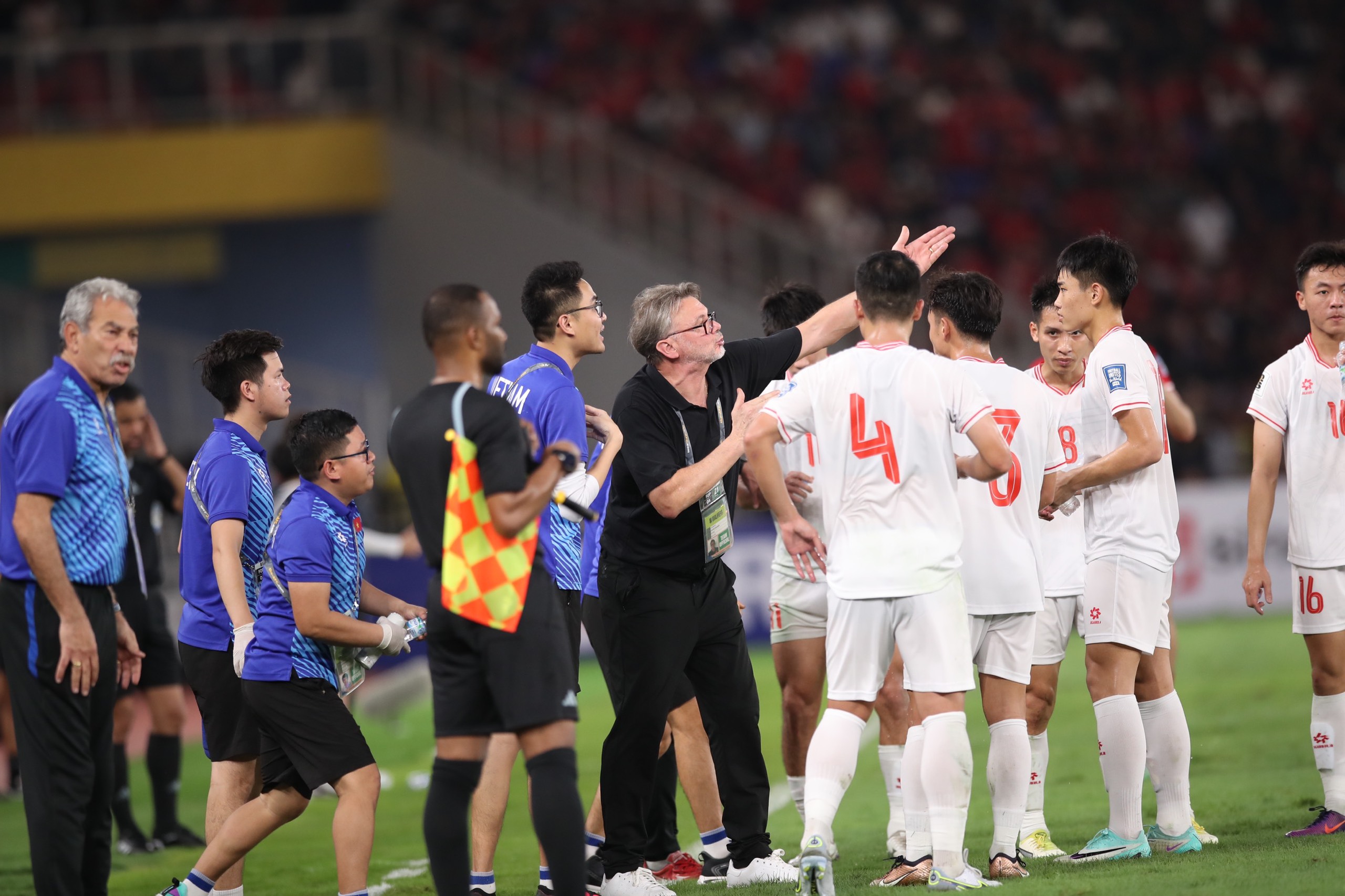 HLV Troussier trao đổi cùng các cầu thủ giữa trận thua 0-1 tại san6 Gelora Bung Karno