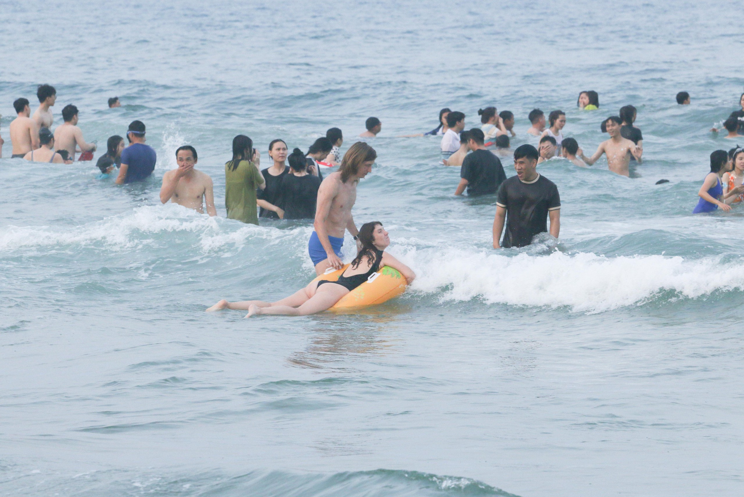 Tại bãi biển khu vực Công viên Biển Đông (Q.Sơn Trà), từ khoảng 16 giờ đã có đông đảo người dân và du khách kéo về đây để được ngâm mình vào dòng nước biển mát lạnh, giải nhiệt nắng nóng