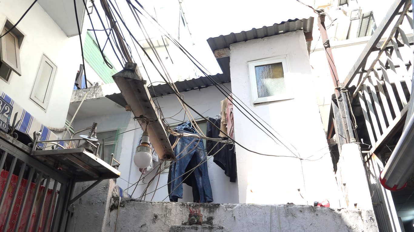 Nhà bà Nguyễn Thị Dung có diện tích 2,4 mét vuông, bà đành sống chật vật trong nhà, bên cạnh đó, máy giặt và bếp nấu ăn được mang ra hiên nhà sử dụng.