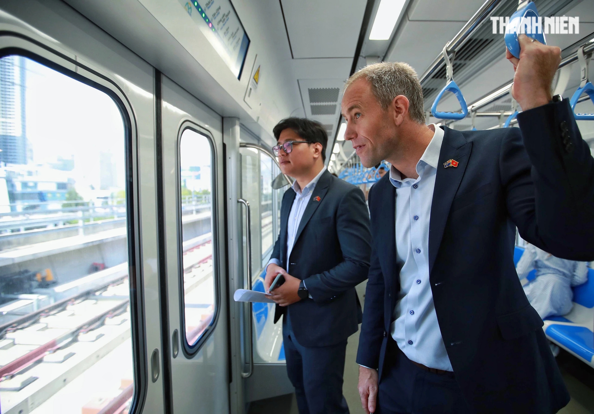 Tổng lãnh sự New Zealand tại TP.HCM, ông Scott James (bên phải) ngắm nhìn quang cảnh TP.HCM trên chuyến tàu metro số 1 khi đi ngang qua sông Sài Gòn