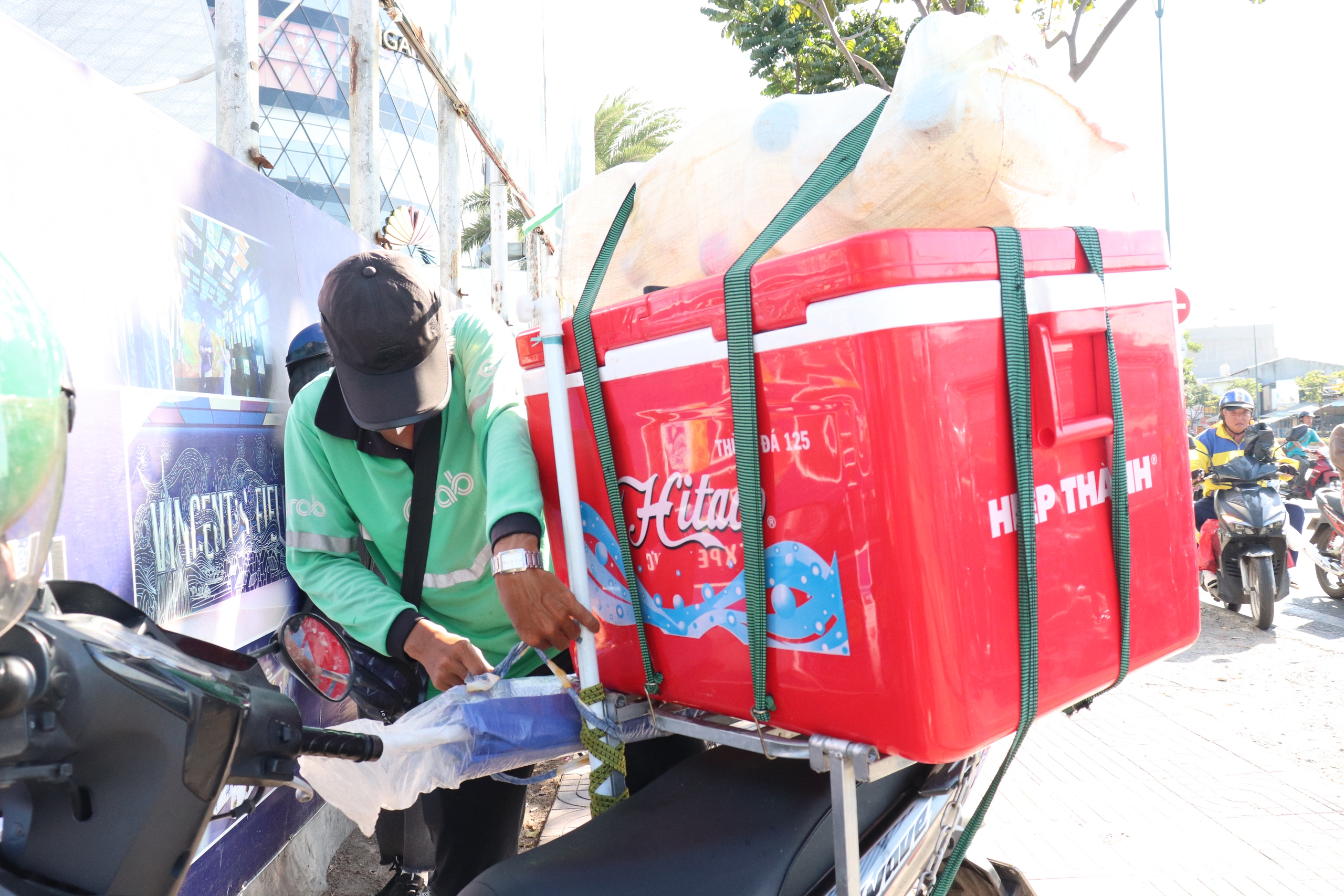 Anh Trần Minh Tuấn tranh thủ buổi trưa tạm ngừng chạy xe để tránh nóng và bán thêm nước giải khát.