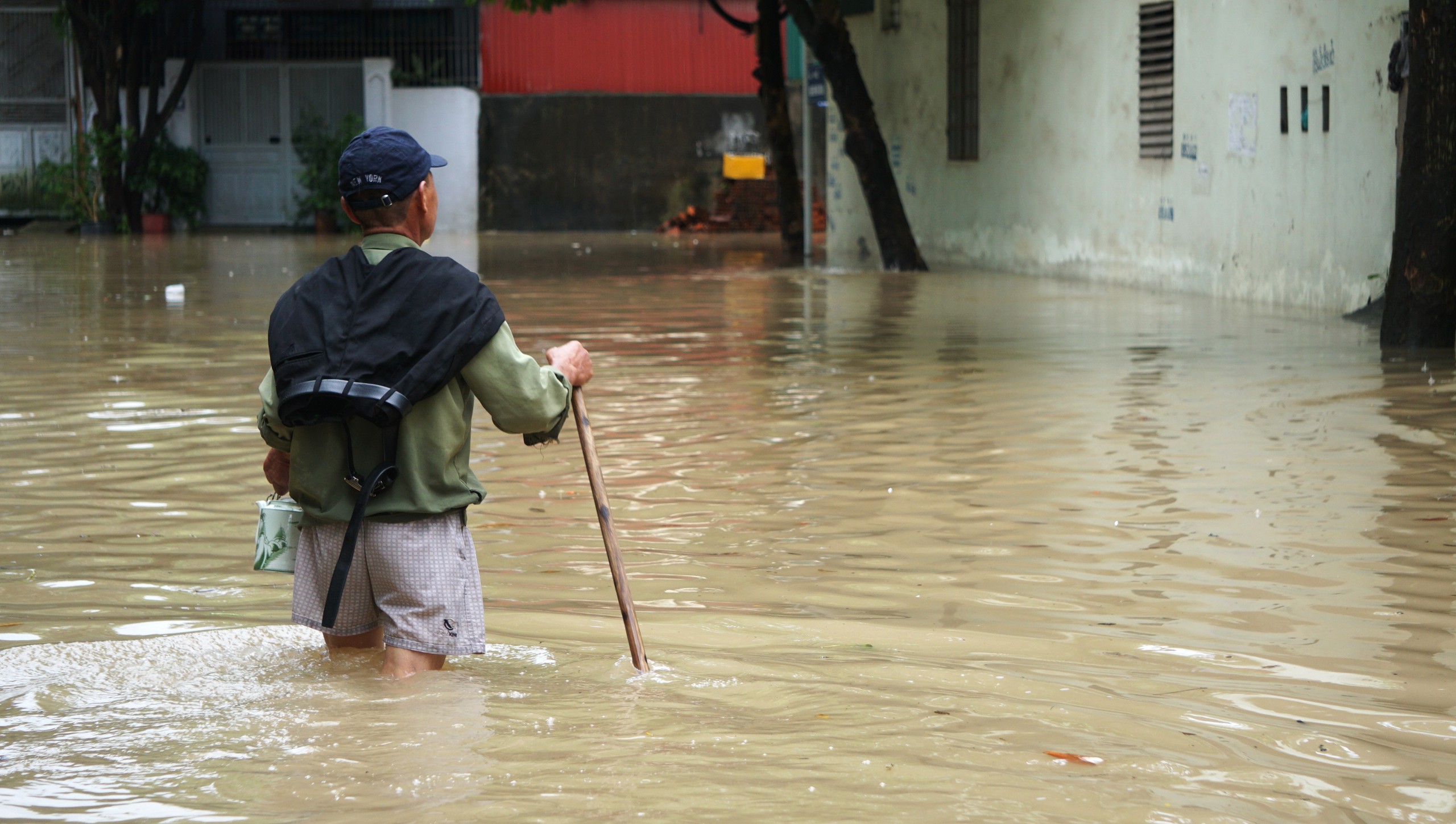 Một người dân ở P.Phú Sơn (TP.Thanh Hóa) phải dùng gậy để dò đường đi vì đường đã ngập sâu từ 50 - 60 cm