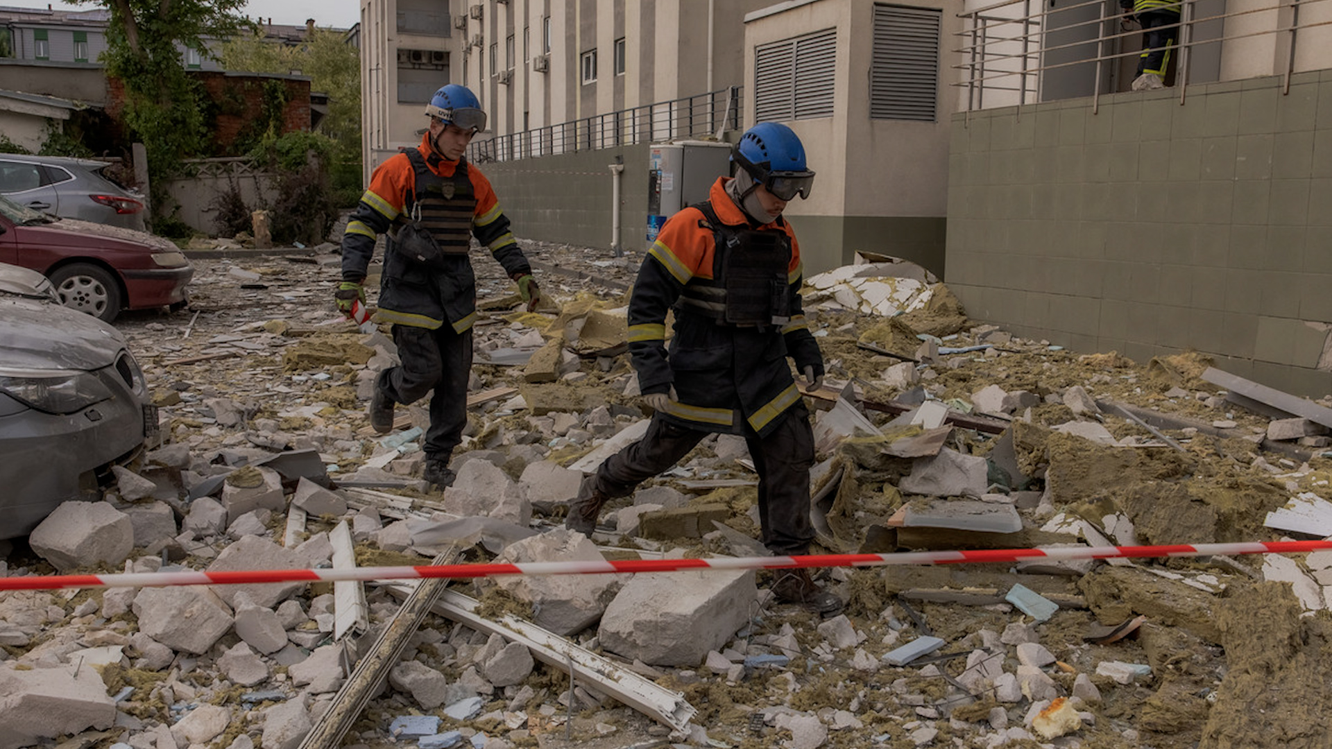 Nhân viên cấp cứu đi giữa đống đổ nát phía trước một tòa nhà dân sự bị hư hại do vụ tấn công tên lửa của Nga ở Kharkiv (Ukraine), ngày 14.5.2024