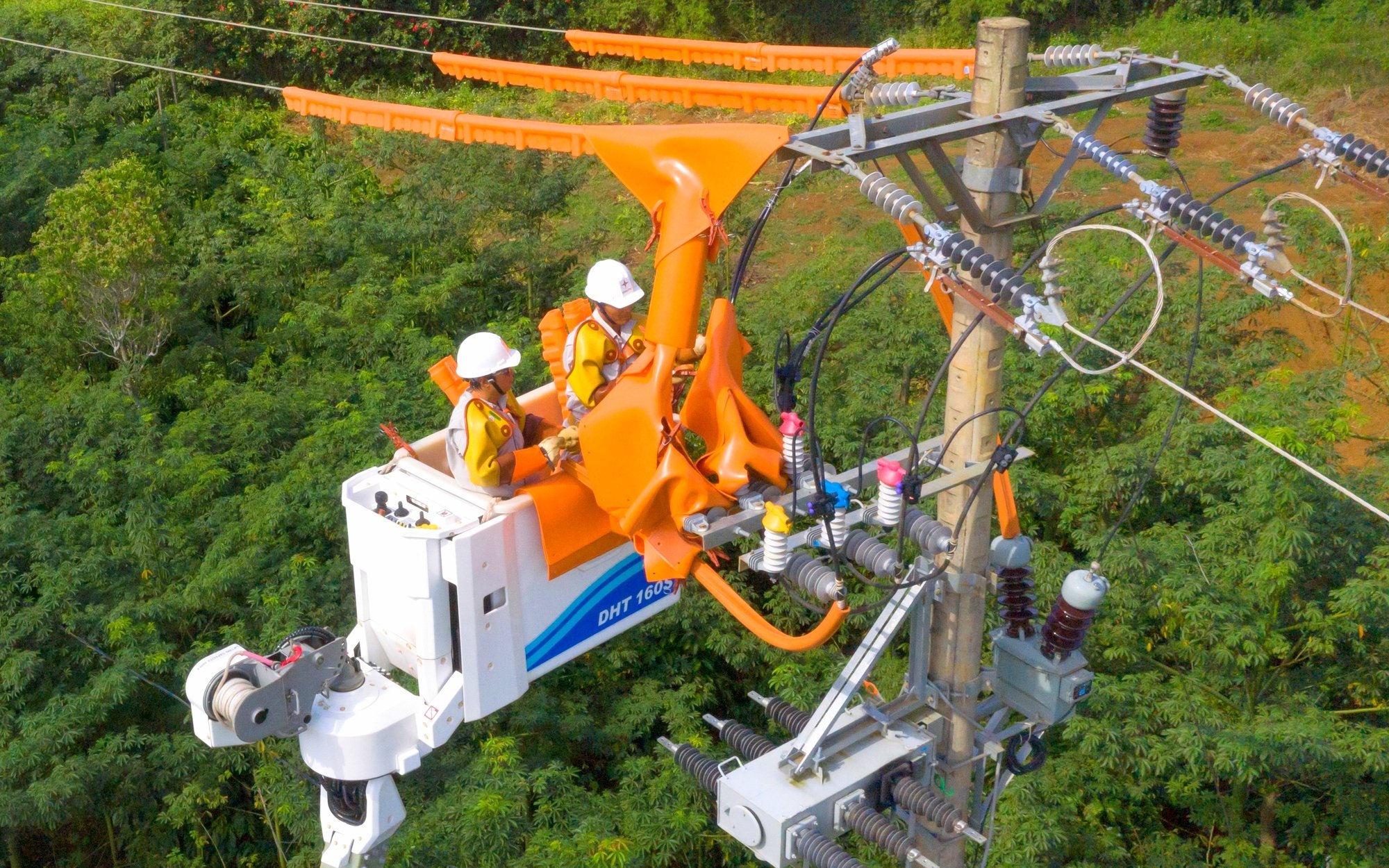 Công nhân ngành điện làm việc trên lưới bảo đảm việc cung cấp điện đến khách hàng