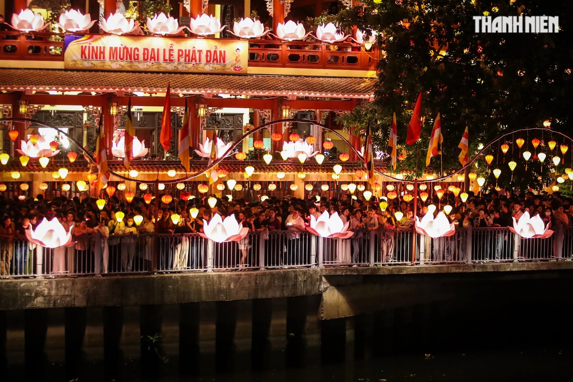 Trong khuôn viên chùa hàng ngàn người dân tham gia thả hoa đăng chen nhau, cố gắng cầm hoa đăng giơ cao để nhích từng chút một tiến về phía bờ kênh Nhiêu Lộc