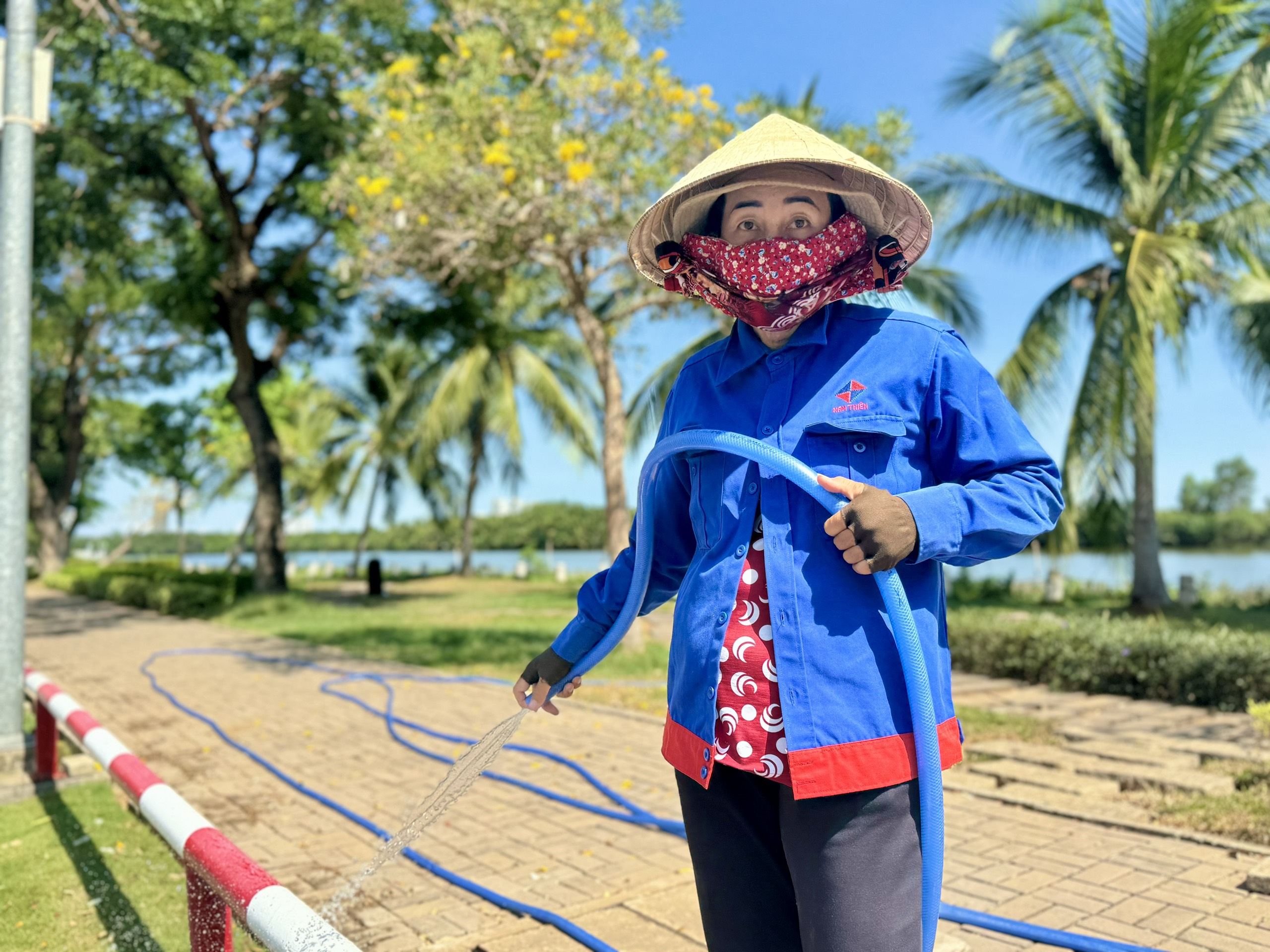 Bà Nguyễn Thị Mười Một (51 tuổi) tưới cây ở đường Trần Văn Trà, gần khu vực công viên bờ sông Panorama vẫn cảm thấy dễ chịu,  không quá nóng bức