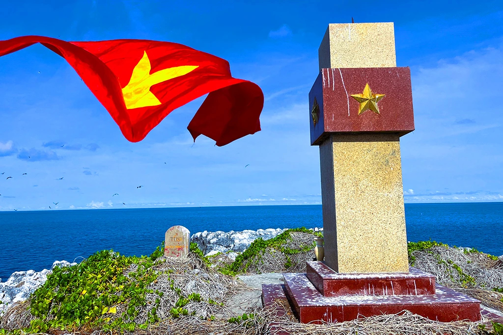 Mốc giới cũ (trái) và cột cờ xây dựng năm 2015 trên đảo Hòn Em