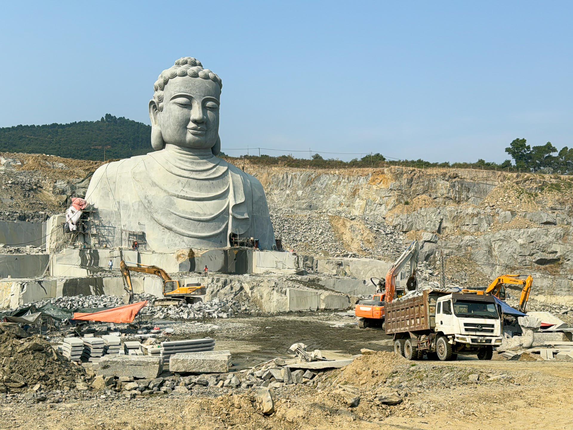 Đơn vị thi công huy động phương tiện cưa, cắt đá xuống sâu để tạo tác phần còn lại của tượng đức Phật Thích Ca Mâu Ni tọa thiền