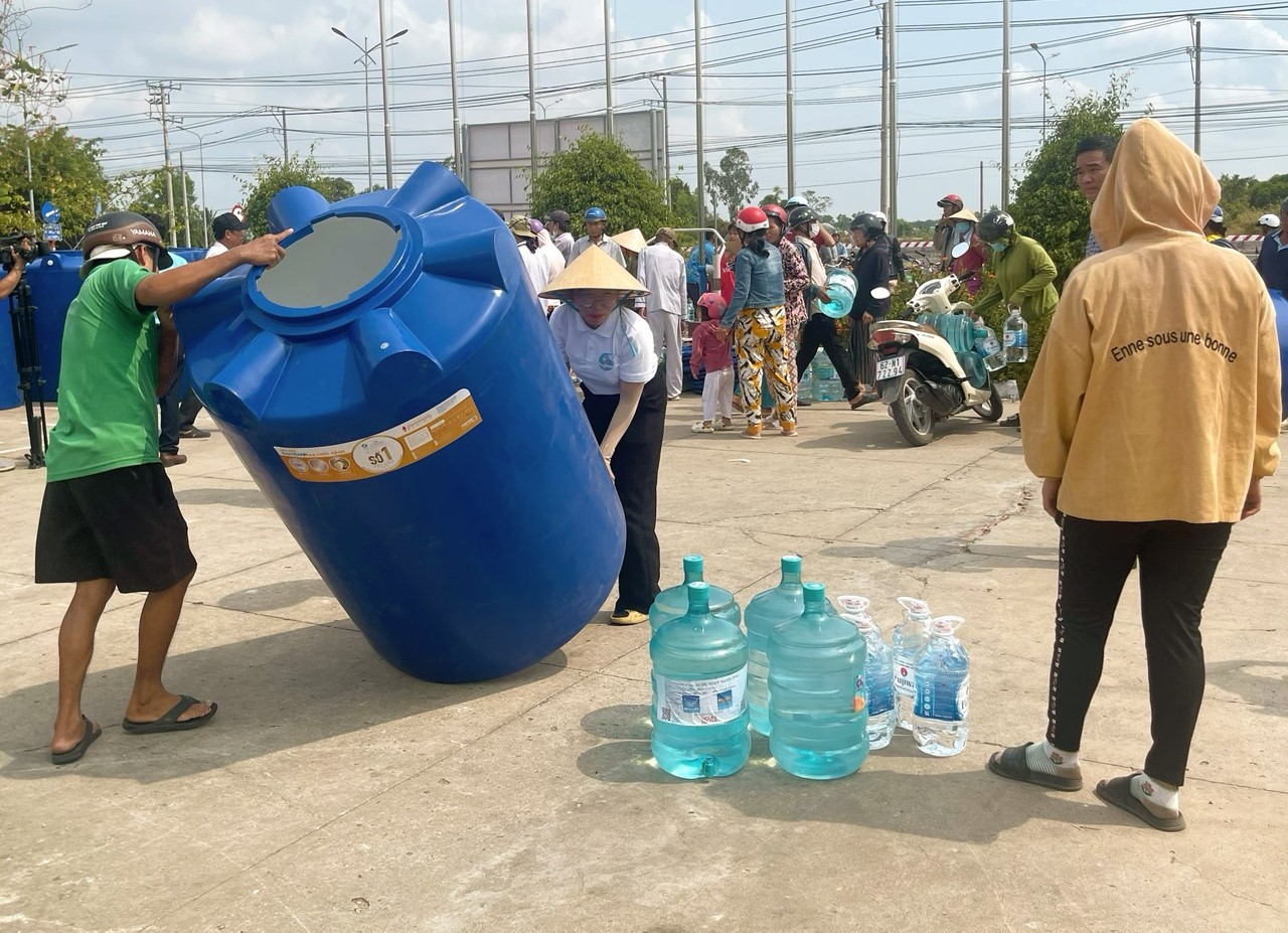 'Nước ngọt nghĩa tình' đến với người dân vùng hạn mặn miền Tây- Ảnh 1. Người dân 2 xã Tân Tập và Phước Vĩnh Đông, huyện Cần Giuộc, tỉnh Long An nhận bồn chứa nước ngọt và bình nước ion kiềm từ chương trình