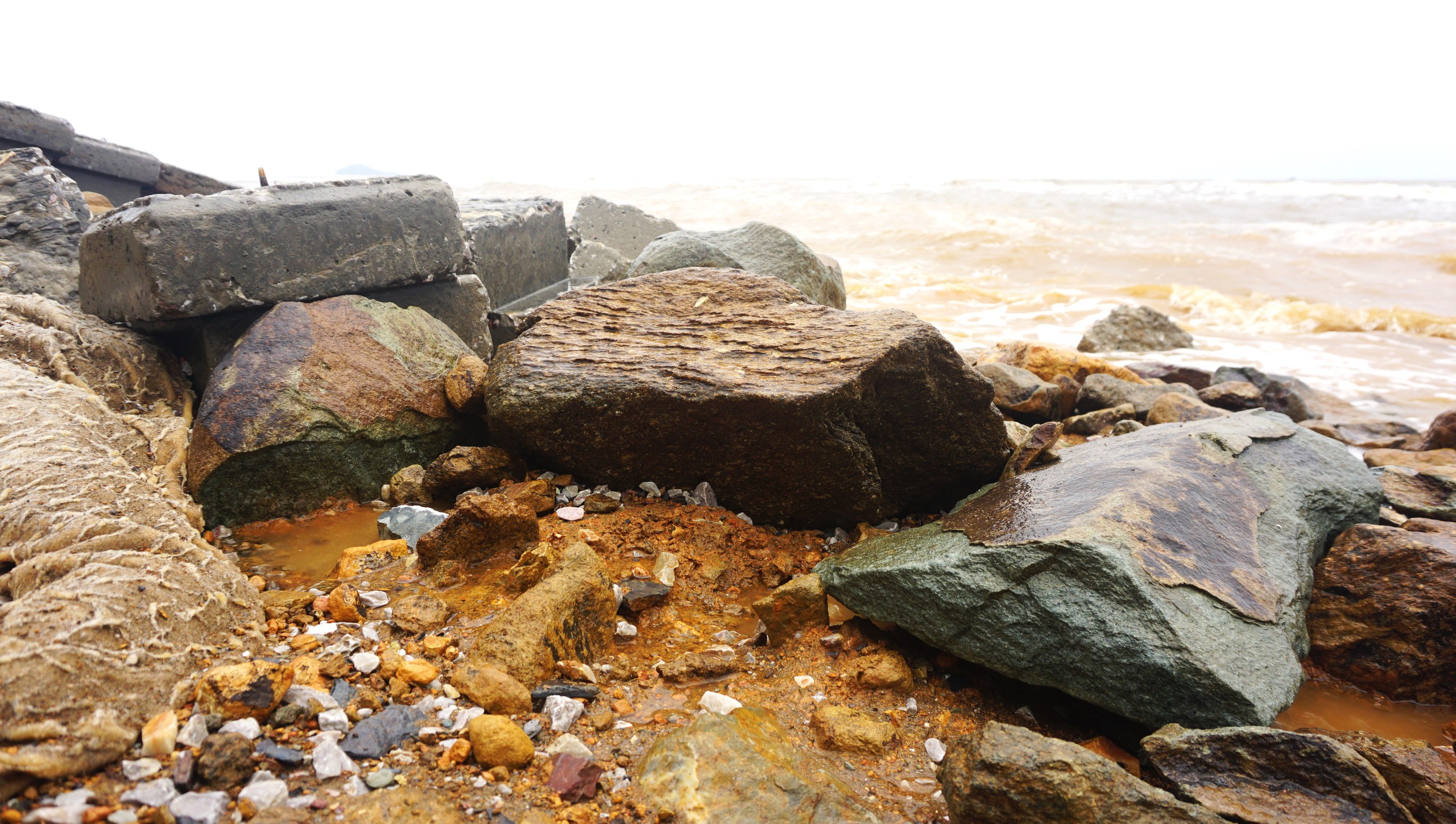 Kè chắn sóng bị sóng đánh lộ ra nhiều tảng đá lớn ở dưới nền kè.