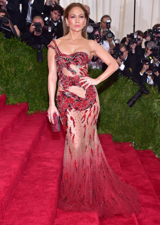 Jennifer Lopez tham dự Met Gala 2015 trong chiếc váy đỏ xuyên thấu của Versace nổi bật với hình ảnh rồng uốn lượn, phù hợp với chủ đề China: Through the Looking Glass.