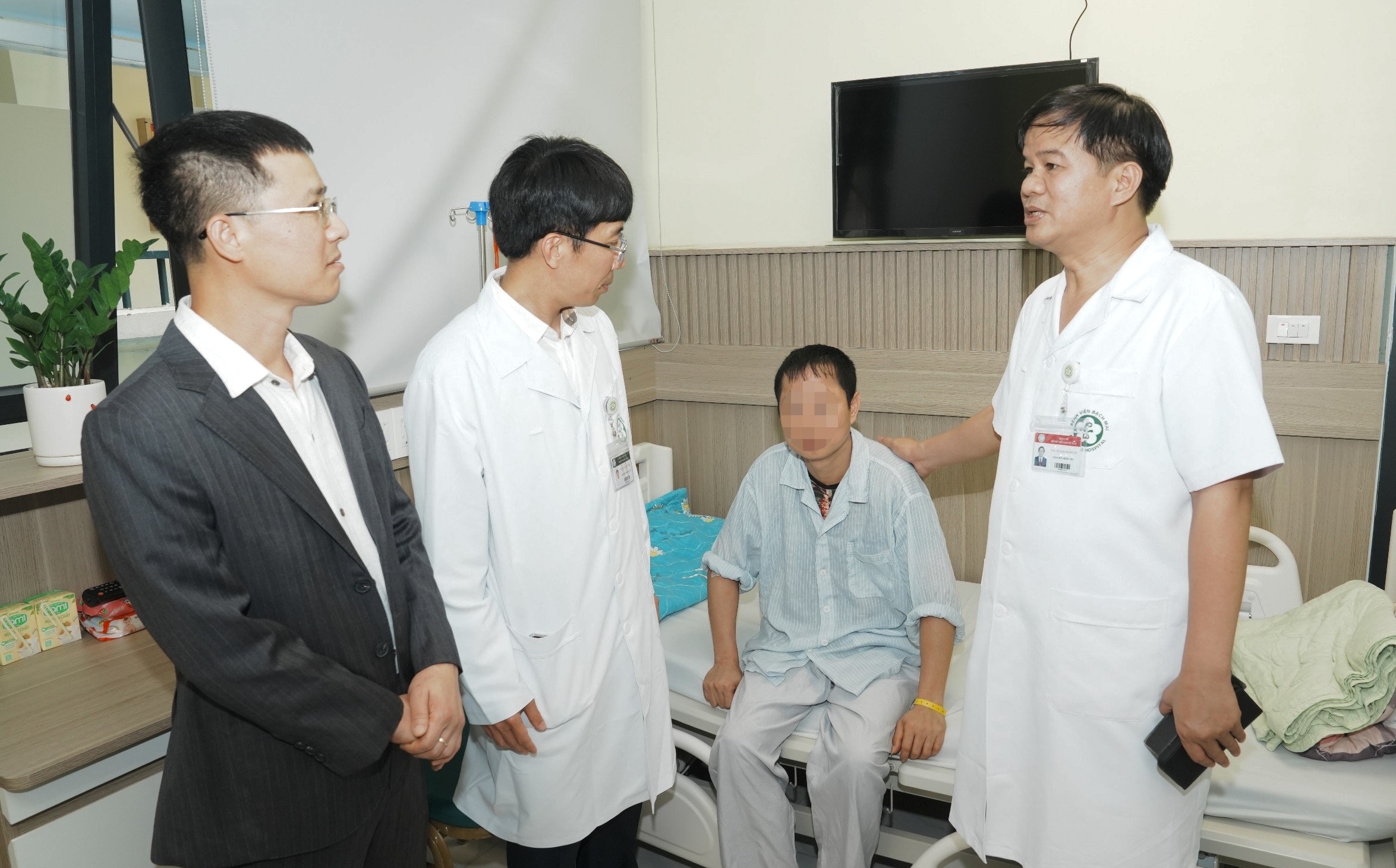 Bệnh viện Bạch Mai mở rộng quy mô tiếp nhận cấp cứu đột quỵ- Ảnh 1. PGS Đào Xuân Cơ (bìa phải) thăm BN tại Trung tâm Đột quỵ và thông tin về việc mở rộng quy mô cấp cứu đột quỵ