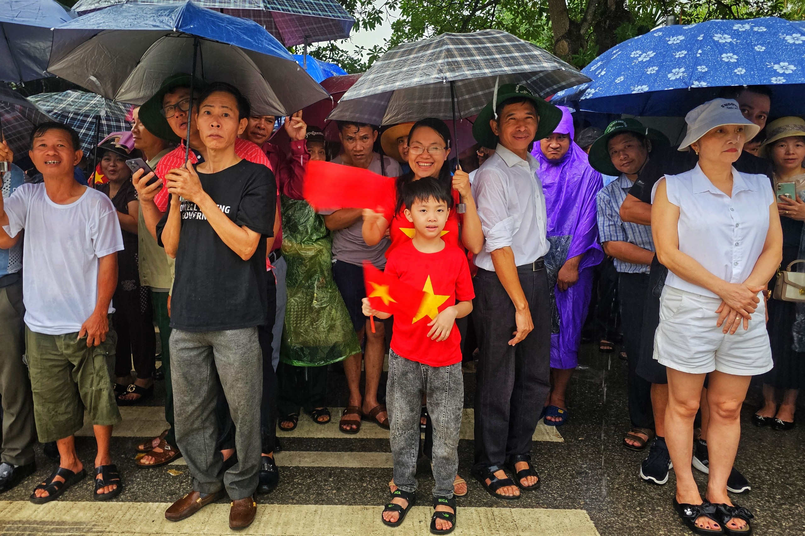 7 giờ sáng trời bắt đầu mưa nặng hạt, nhưng không cản được dòng người háo hức chờ đón đoàn diễu binh, diễu hành đi qua