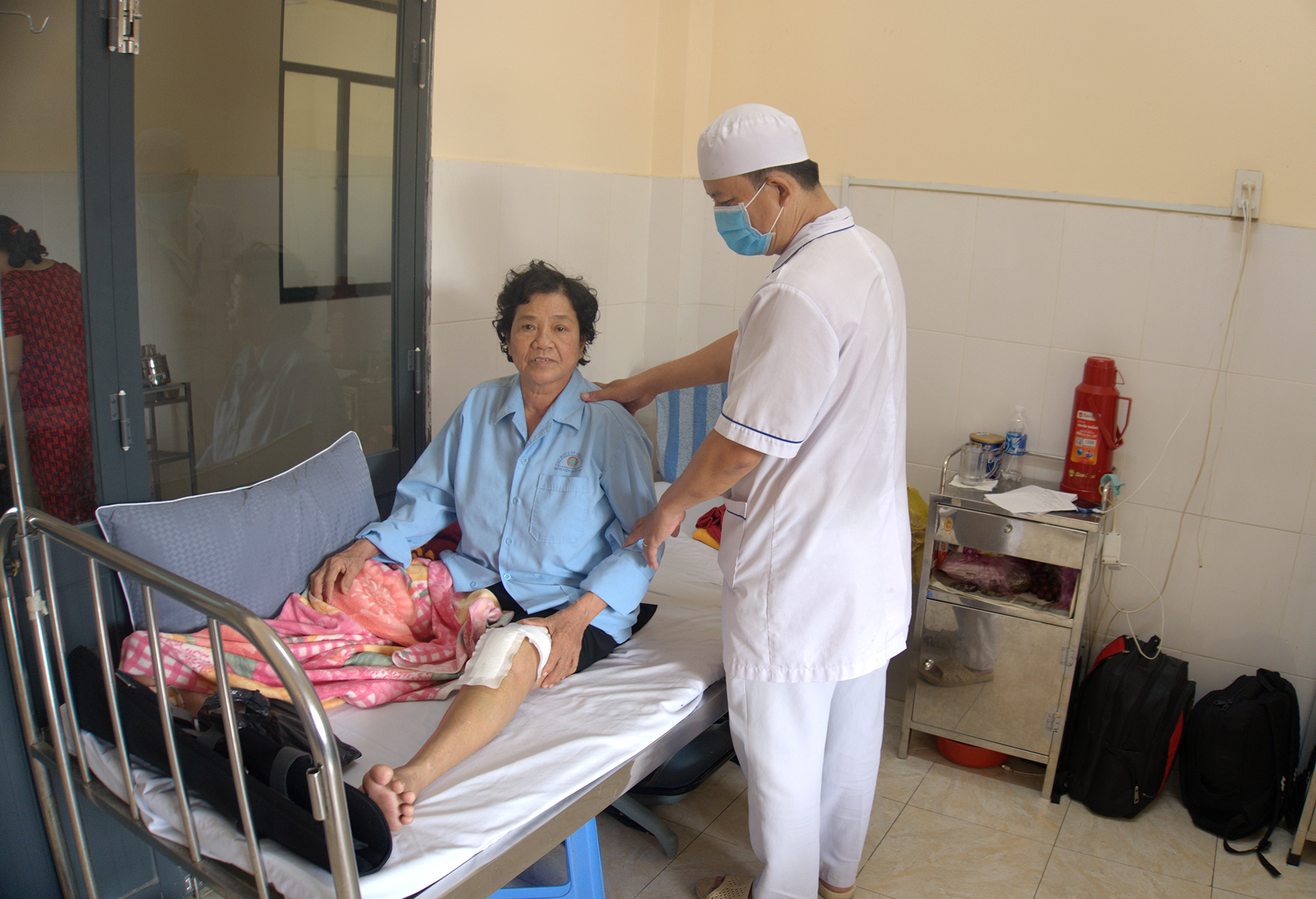 Điều dưỡng chăm sóc bệnh nhân Nguyễn Thị Thu sau 2 ngày phẫu thuật thay khớp gối. ẢNH: TRẦN NGỌC CƯỜNG Điều dưỡng chăm sóc bệnh nhân Nguyễn Thị Thu sau 2 ngày phẫu thuật thay khớp gối. ẢNH: TRẦN NGỌC CƯỜNG