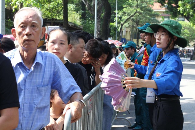 Thanh niên tình nguyện sẵn sàng quạt tay hàng giờ liền để làm mát cho người dân chờ viếng Tổng Bí thư - Ảnh 1.