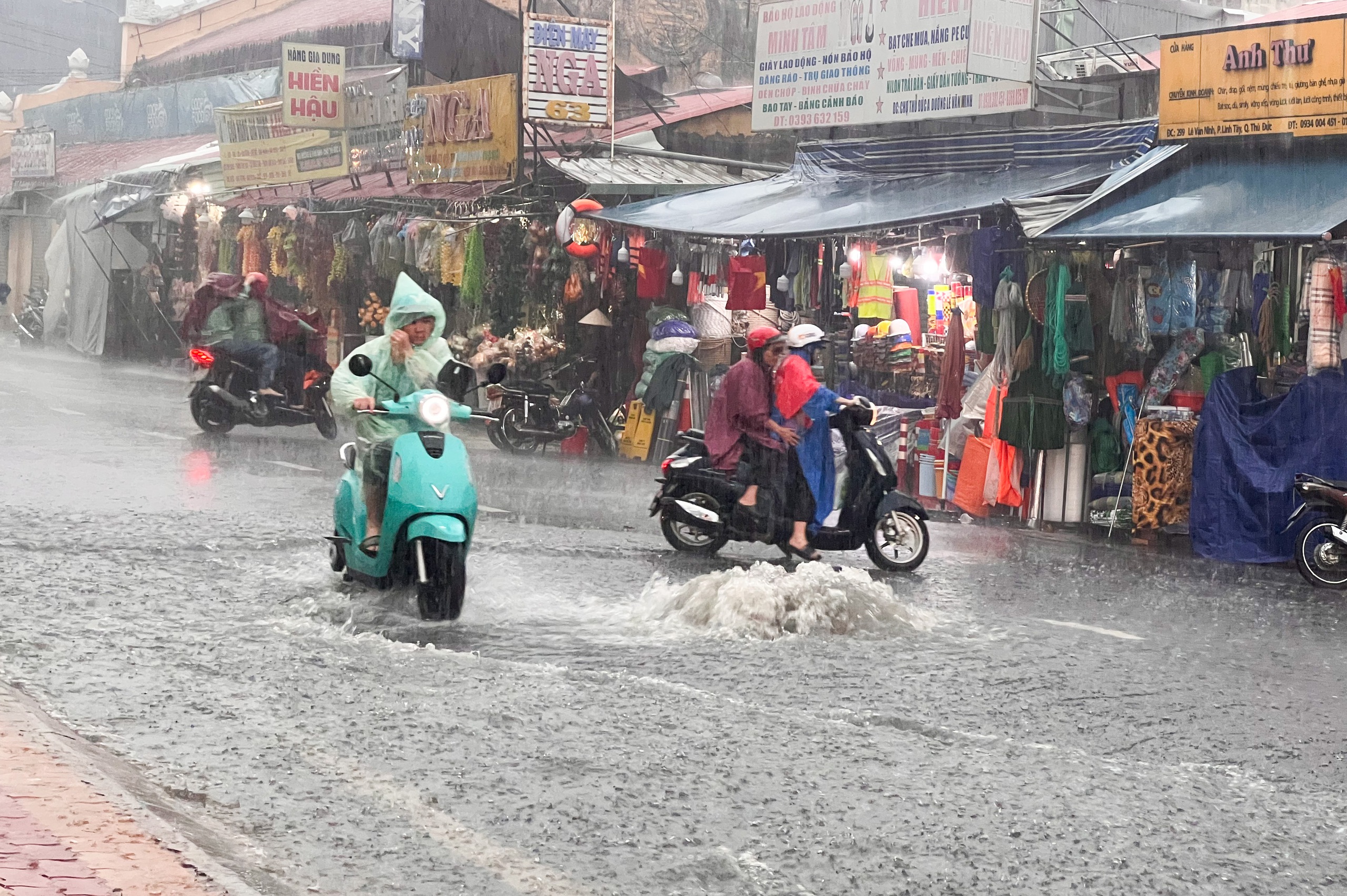 TP.HCM có mưa cực to: Nắp cống bung, nước cuồn cuộn ngập gần bánh xe- Ảnh 1.