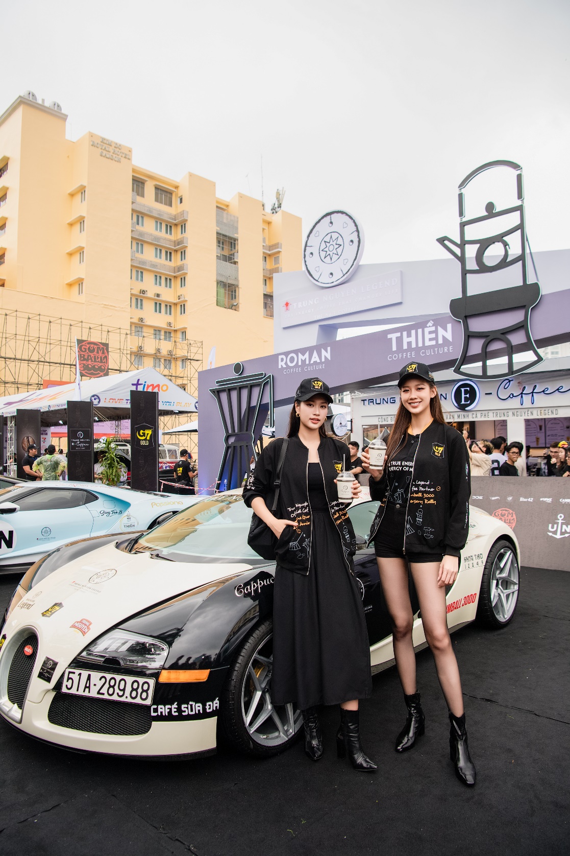 Two women standing next to a car  Description automatically generated