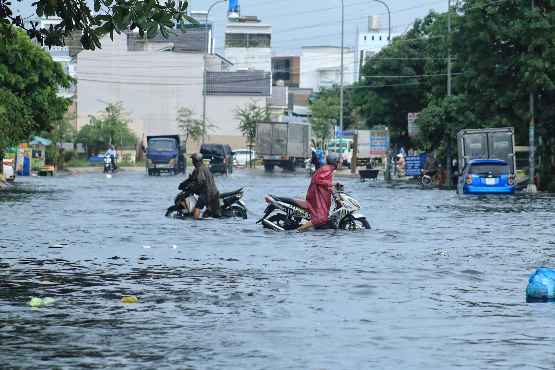 Cơn mưa chiều ở TP.HCM có đường nước ngập gần tới yên xe, nhiều người ngỡ ngàng- Ảnh 1.