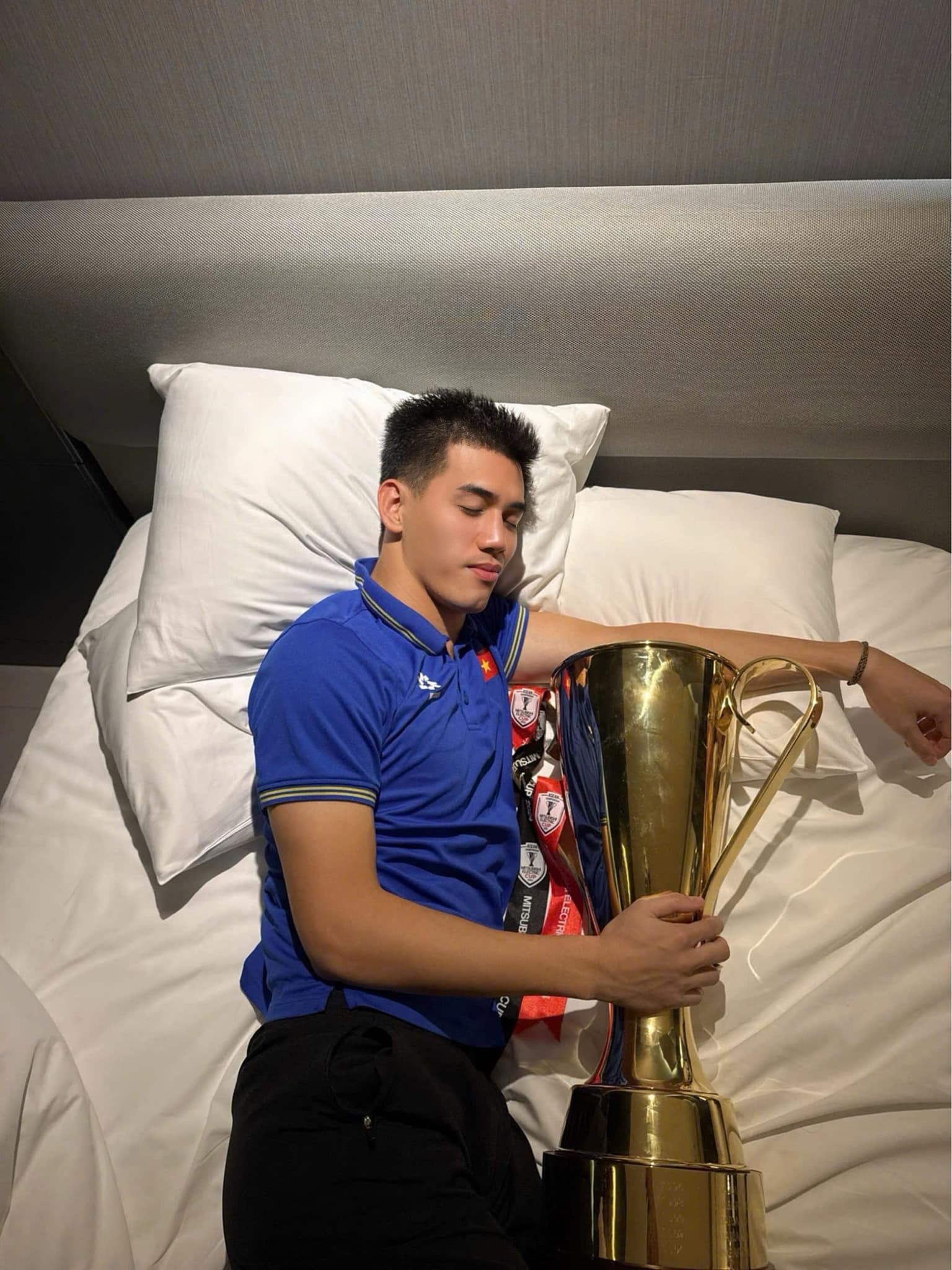 Tien Linh shows off the image of sleeping with the AFF Cup 2024 championship trophy