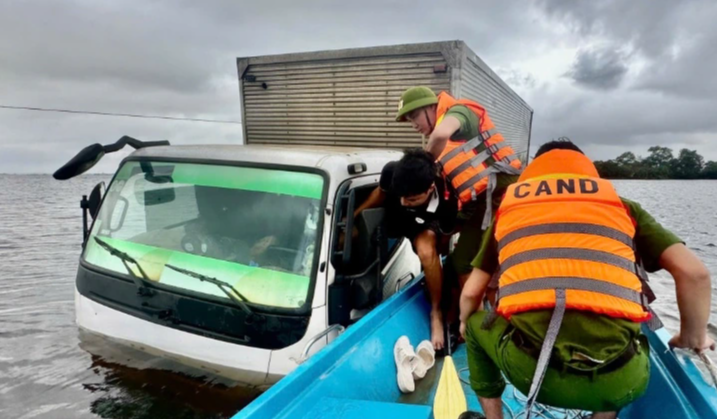 Quốc lộ 49C ngập sâu, 2 người mắc kẹt trên xe tải bị chết máy - Ảnh 1.