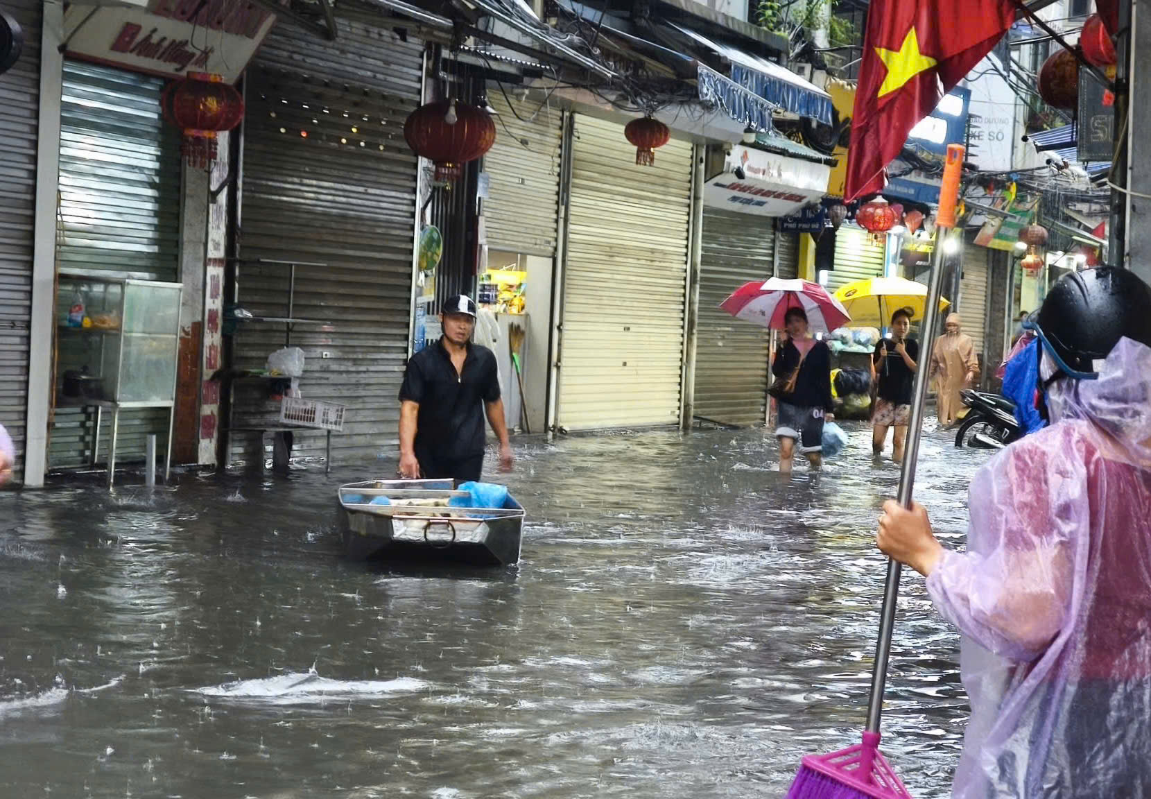 Người dân Hà Nội chật vật 'đắp đập' ngăn nước, đi thuyền trên phố- Ảnh 12.