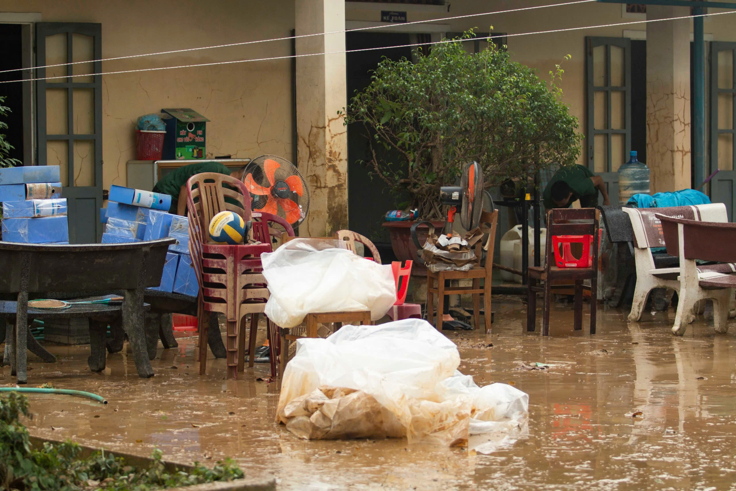 Soldiers wade through mud to help teachers clean up school after flood