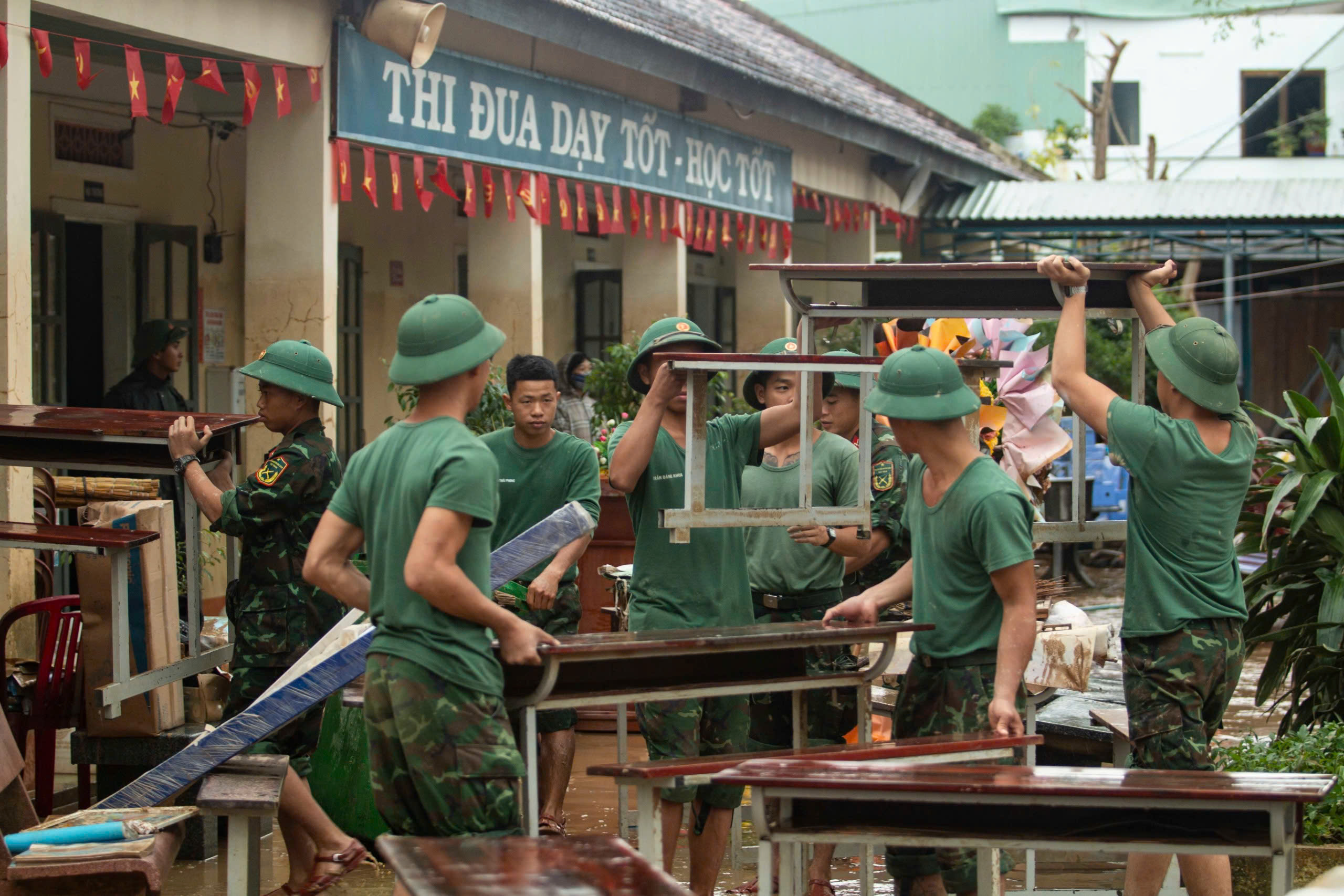 Soldiers wade through mud to help teachers clean up school after flood