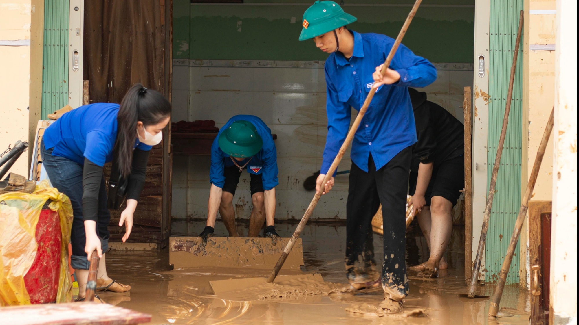 Đoàn viên đội mưa, ngâm nước lũ giúp dân dọn nhà cửa, quét bùn đất - Ảnh 1.
