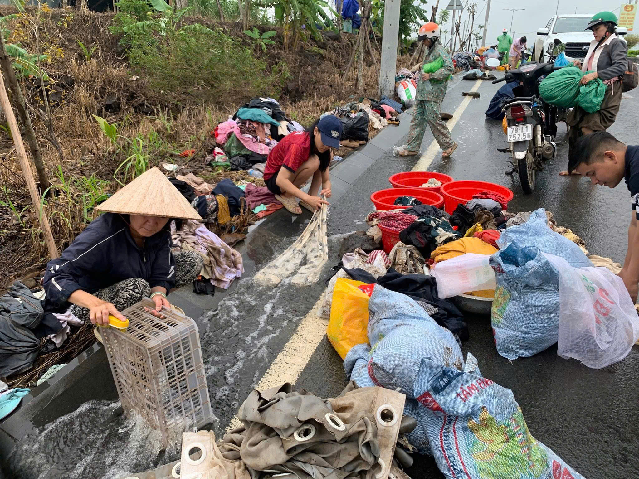 Người dân vùng lũ Đắk Lắk đem quần áo ra đường giặt, dựng bếp tạm nấu cơm - Ảnh 1.