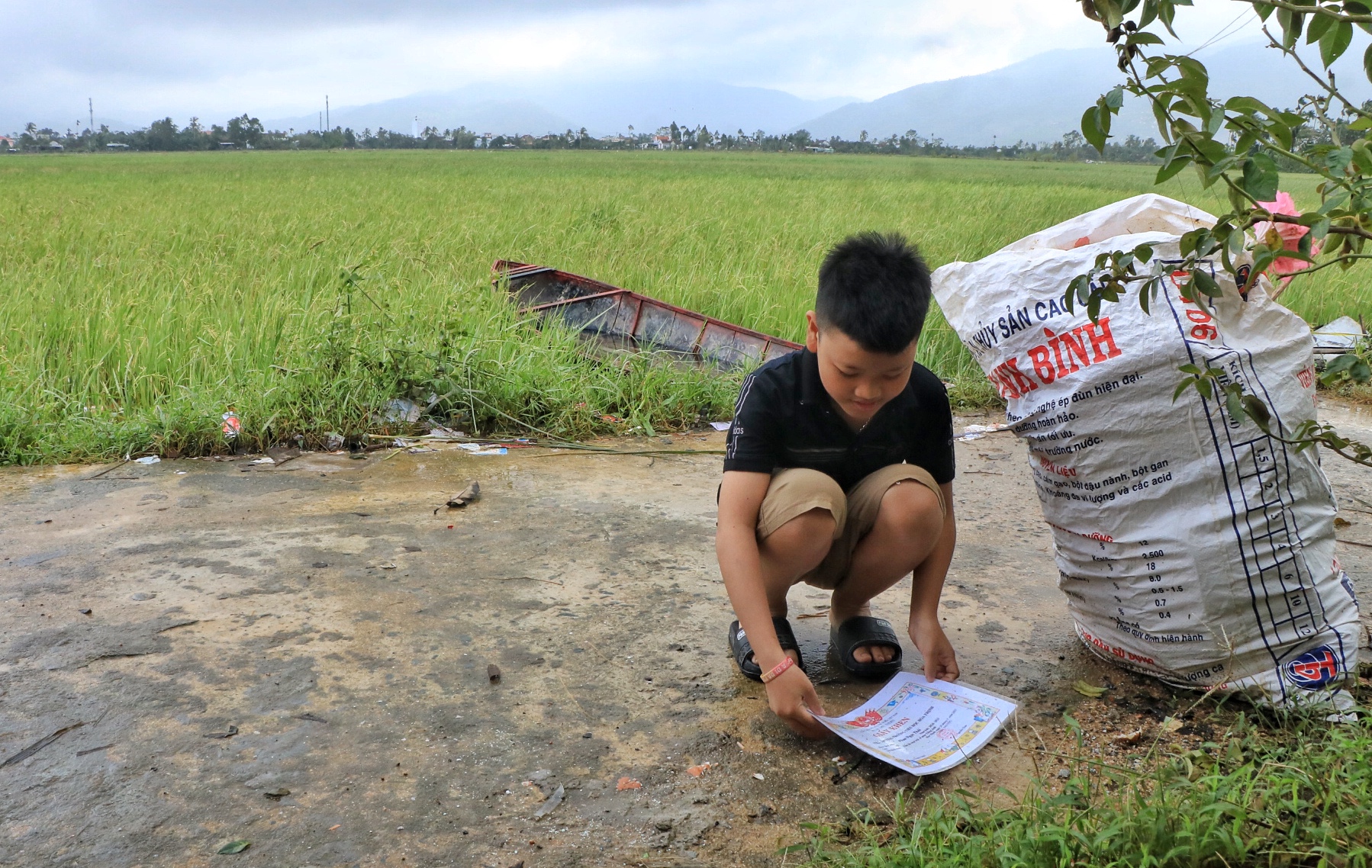 Học sinh lượm lại giấy khen trôi theo nước lũ: 'Sách vở của con ướt hết rồi!'- Ảnh 1.