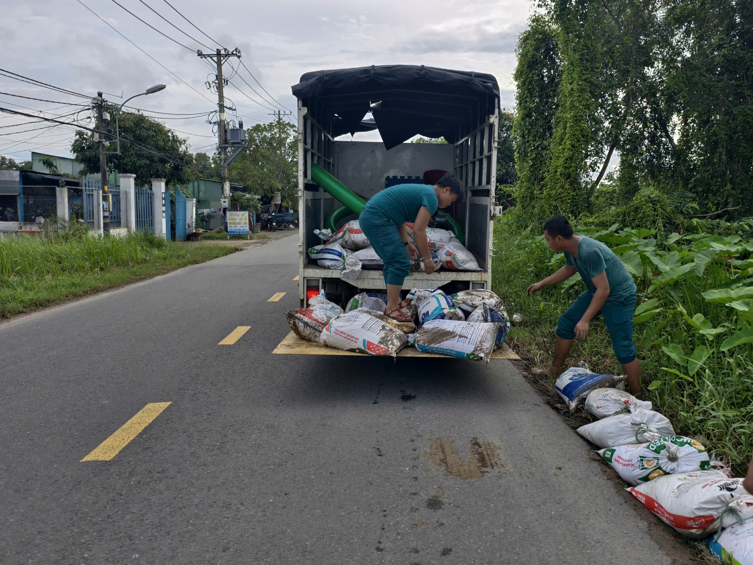 Hàng chục người đắp bao cát ngăn triều cường tại đường Đặng Công Bỉnh - Ảnh 2.