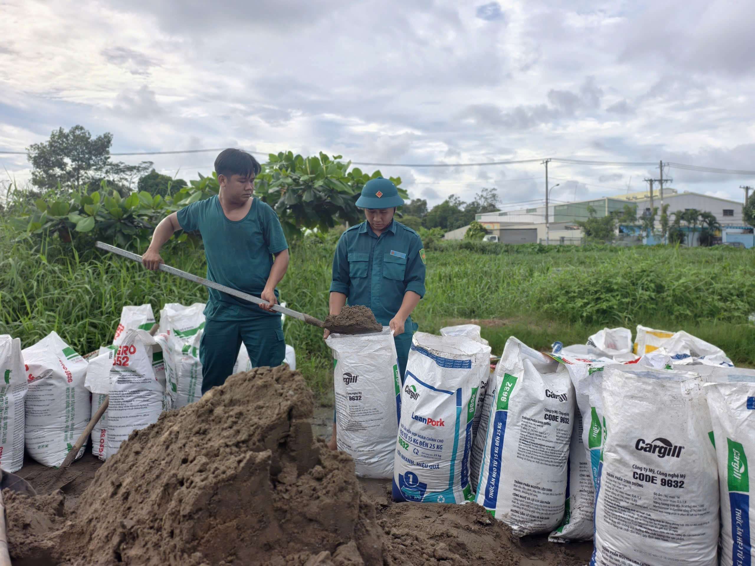 Hàng chục người đắp bao cát ngăn triều cường tại đường Đặng Công Bỉnh - Ảnh 1.